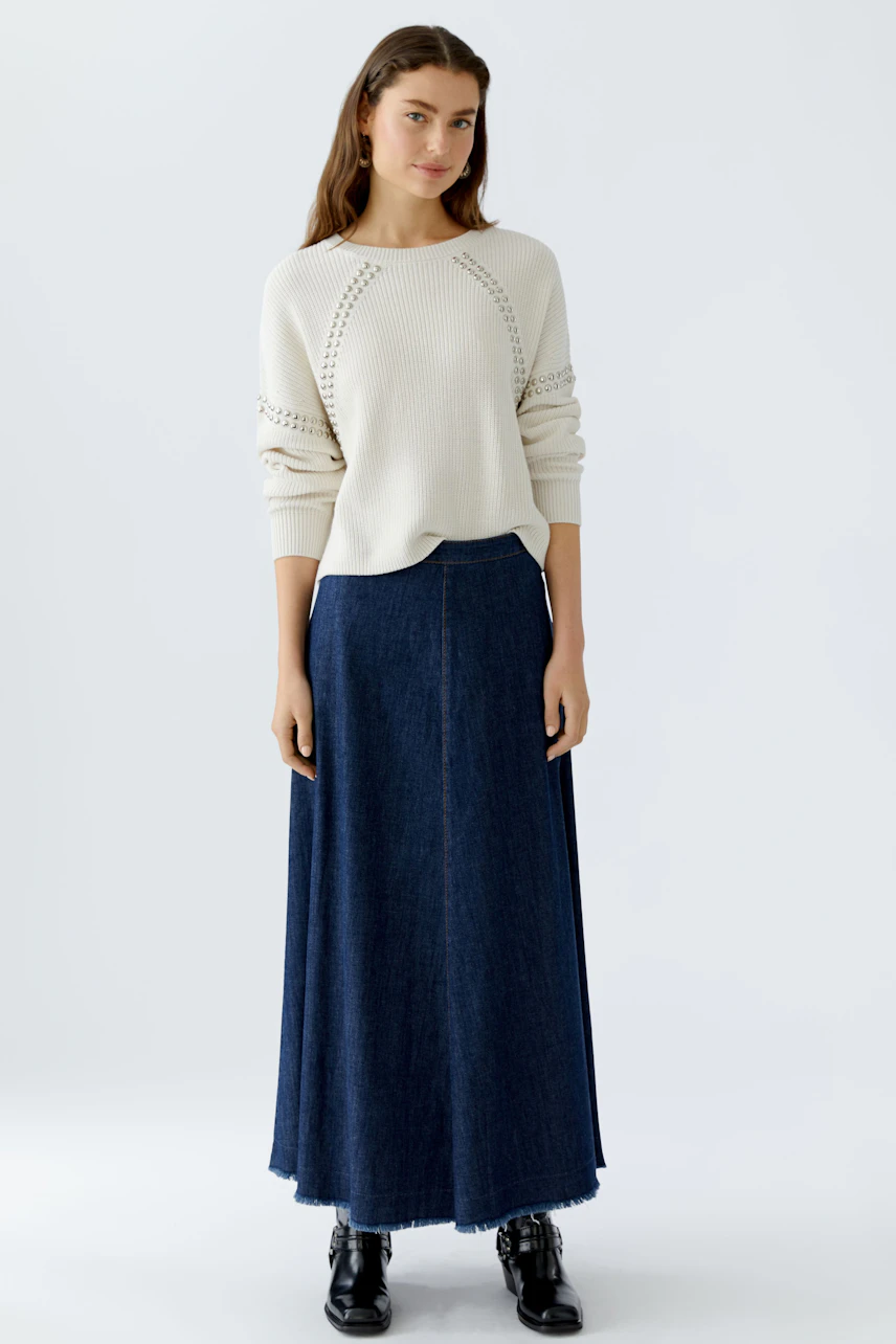 Casual women's pullover: A woman in a light cream pullover with a relaxed fit and stylish details.