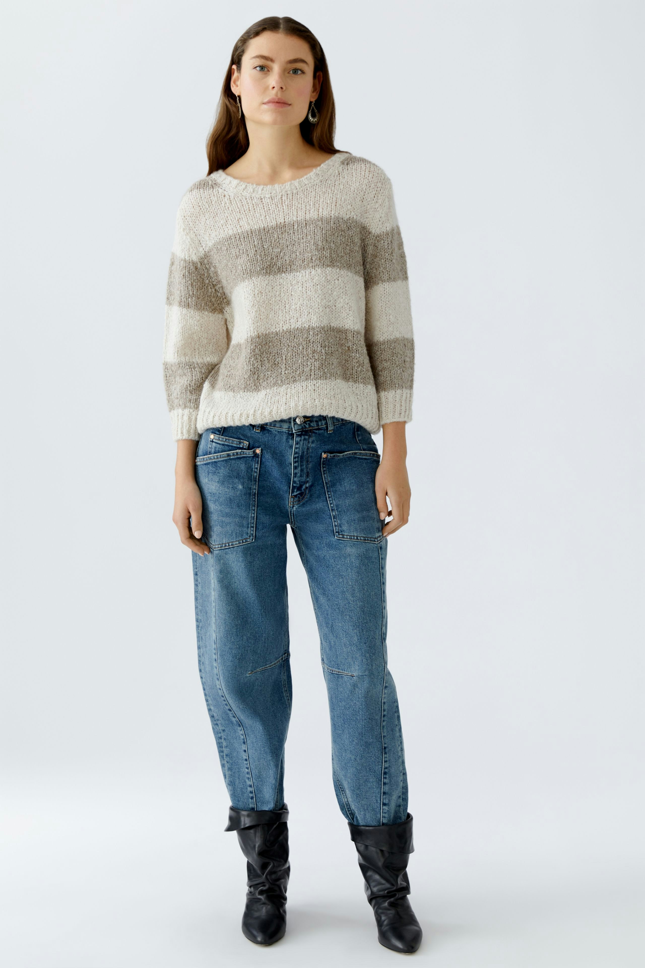 Casual women's pullover: A woman in a striped pullover with neutral tones and relaxed fit.