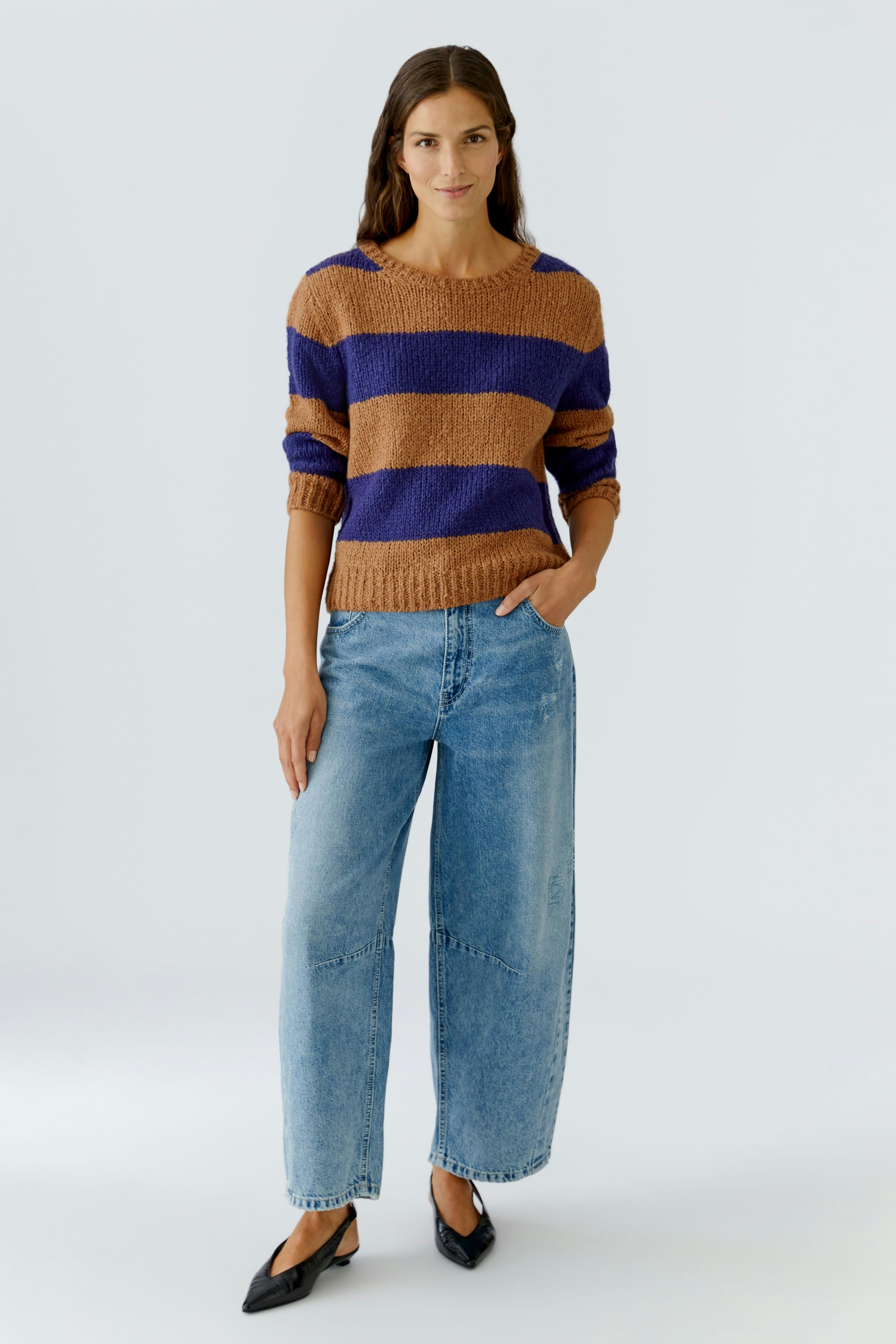 Damen-Pullover: Frau in gestreiftem Pullover in Braun und Blau, kombiniert mit lässigen Jeans.