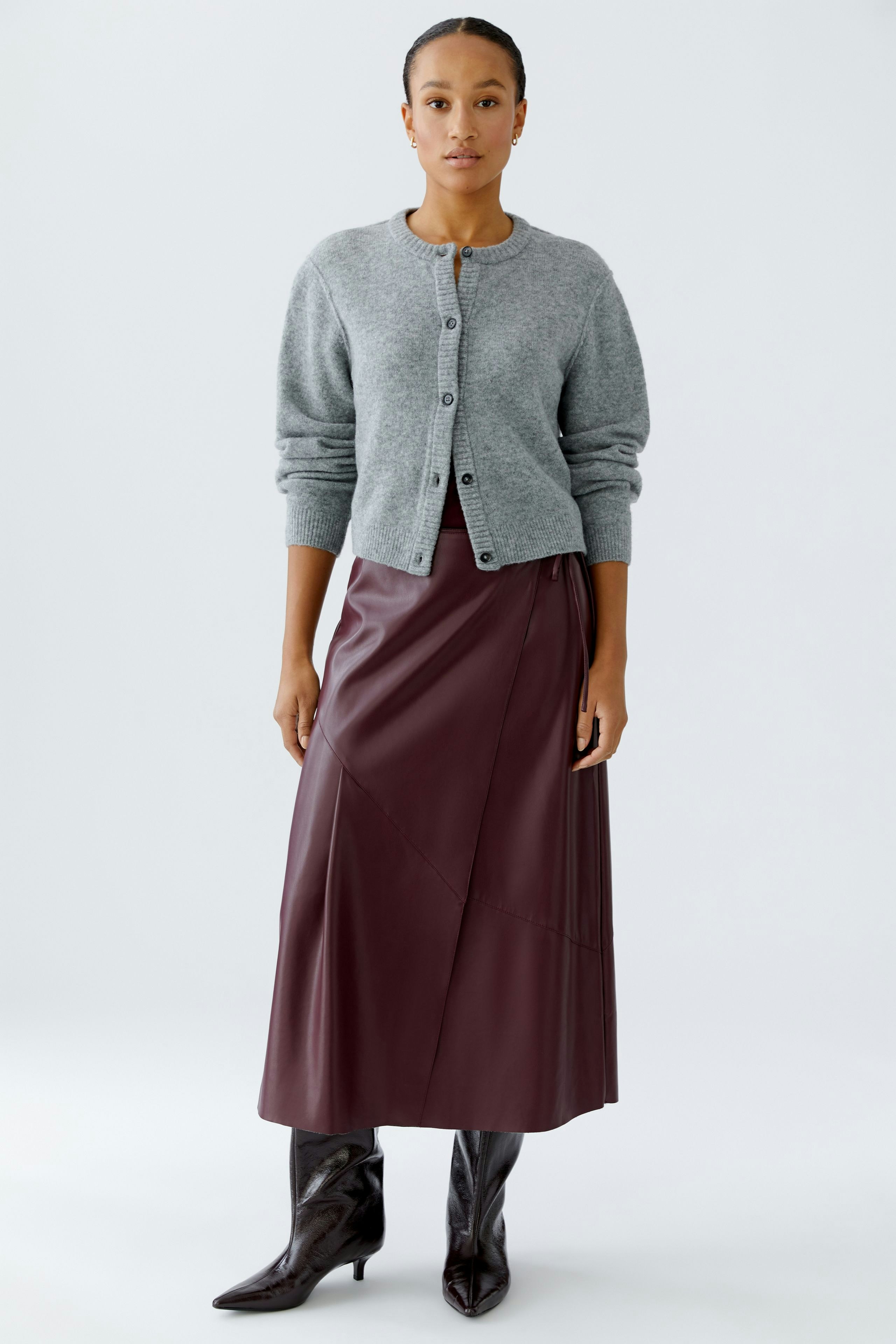 Casual women's cardigan: A woman in a gray cardigan over a burgundy skirt, exuding a relaxed vibe.