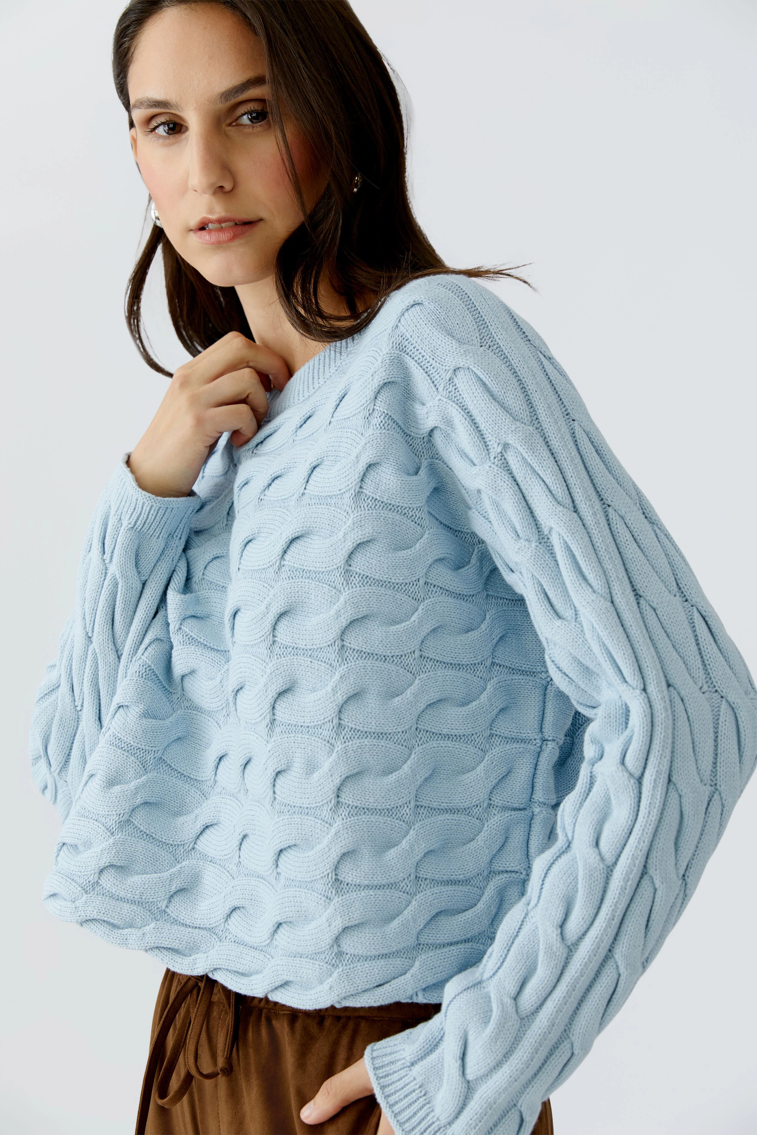 Damen-Pullover: Junge Frau in hellblauem, strukturiertem Strickpullover mit lässigem Schnitt.