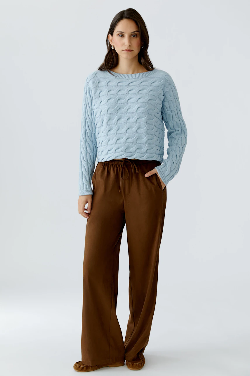 Damen-Pullover in Hellblau: Frau trägt einen strukturierten Pullover mit lässigem Schnitt.