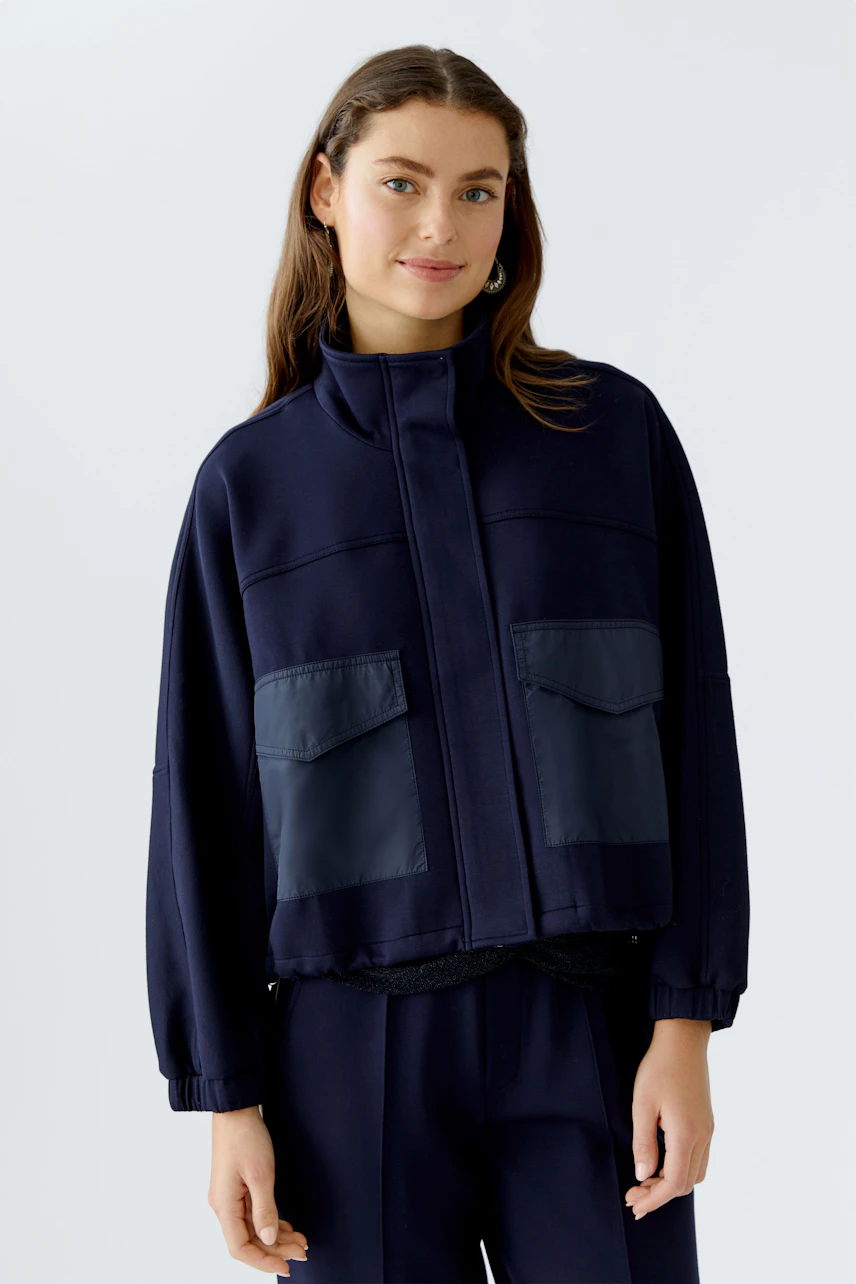 Damen-Jacke: Junge Frau in navyfarbener Jacke mit zwei aufgesetzten Taschen und sportlichem Schnitt.