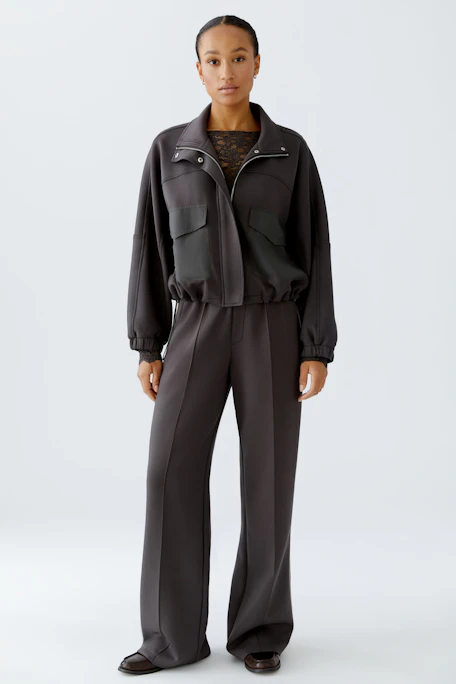 Casual women's jacket: Black jacket with two front pockets and a high collar.