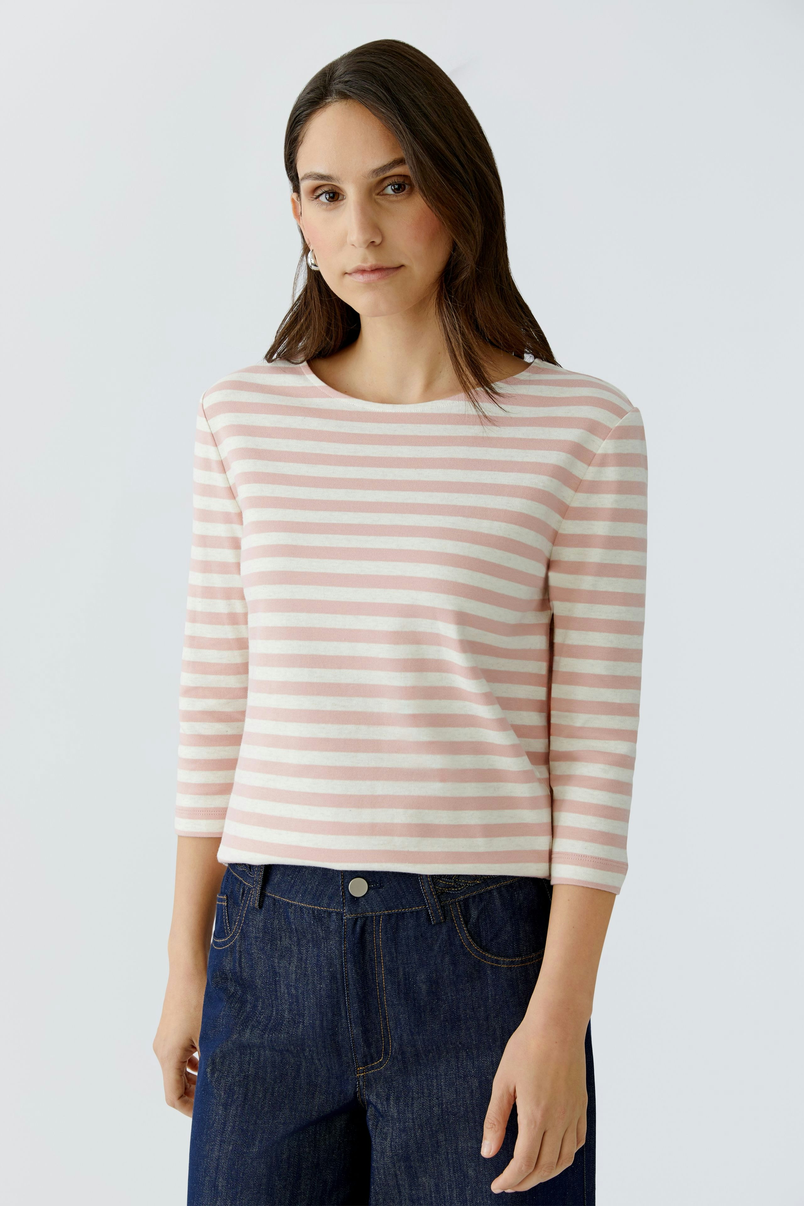 Damen-T-Shirt: Frau in gestreiftem, rosa T-Shirt mit 3/4-Ärmeln und lässiger Jeans.