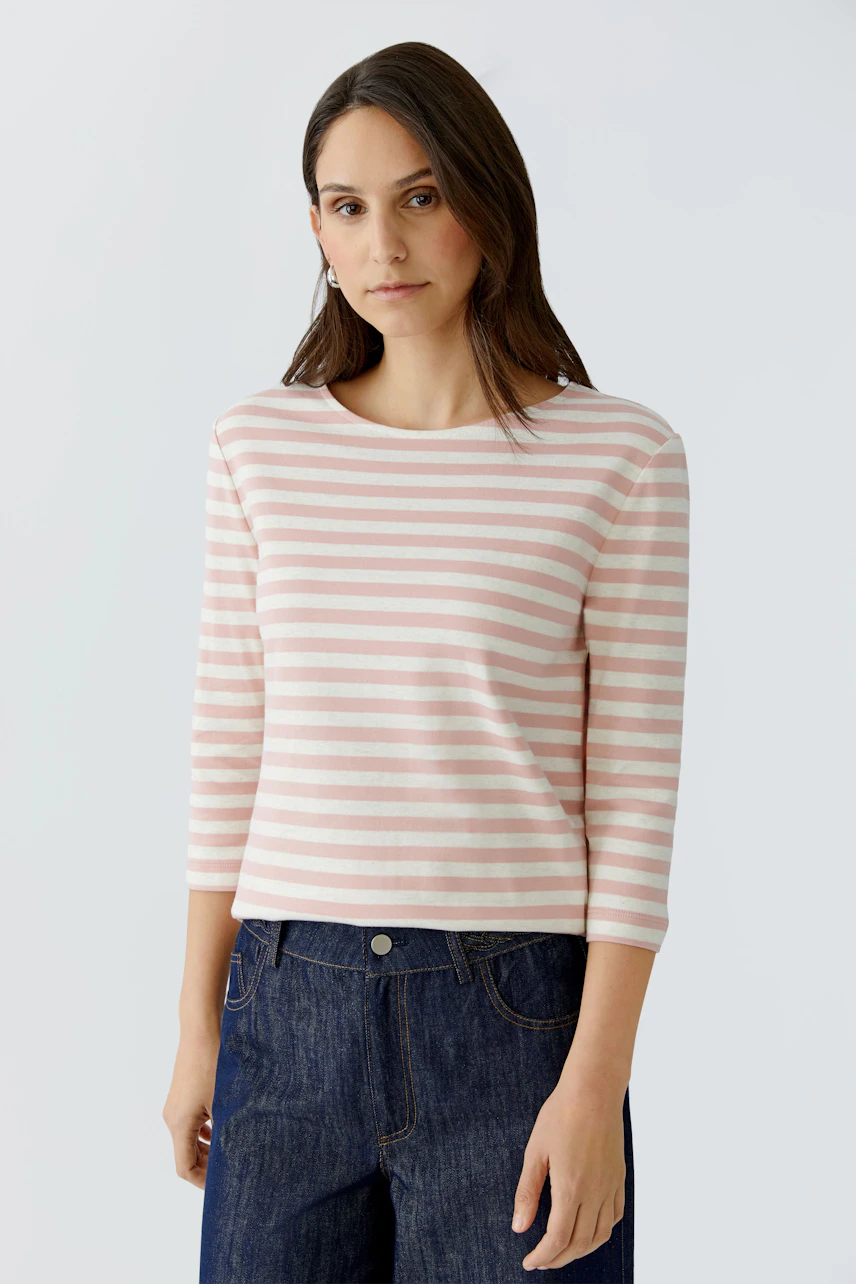 Damen-T-Shirt: Frau in gestreiftem, rosa T-Shirt mit 3/4-Ärmeln und lässiger Jeans.