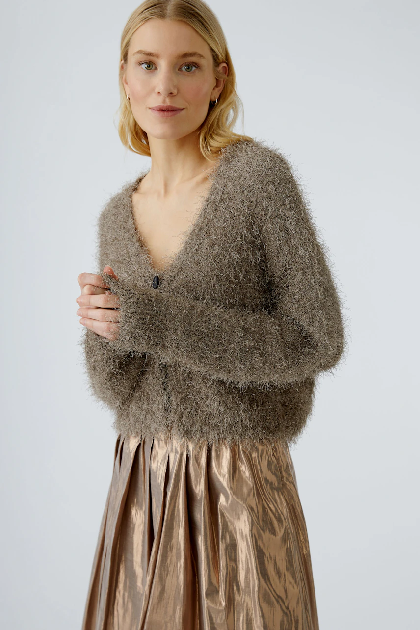 Bequeme Damen-Strickjacke: Frau in flauschiger, grauer Strickjacke mit V-Ausschnitt und Knöpfen.