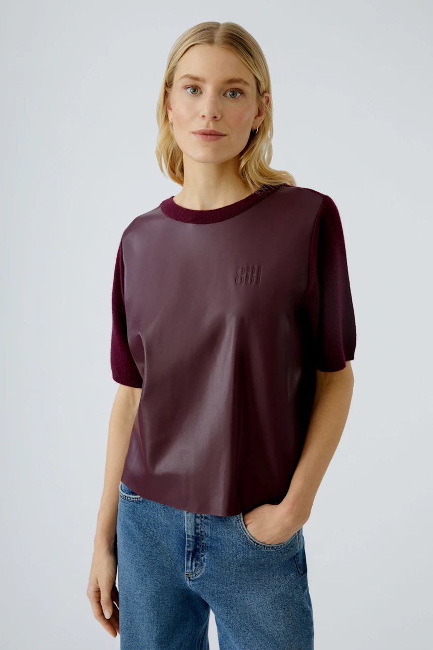 Damen-Pullover: Frau in bordeauxfarbenem, lässigem Pullover mit kurzen Ärmeln und modernem Design.