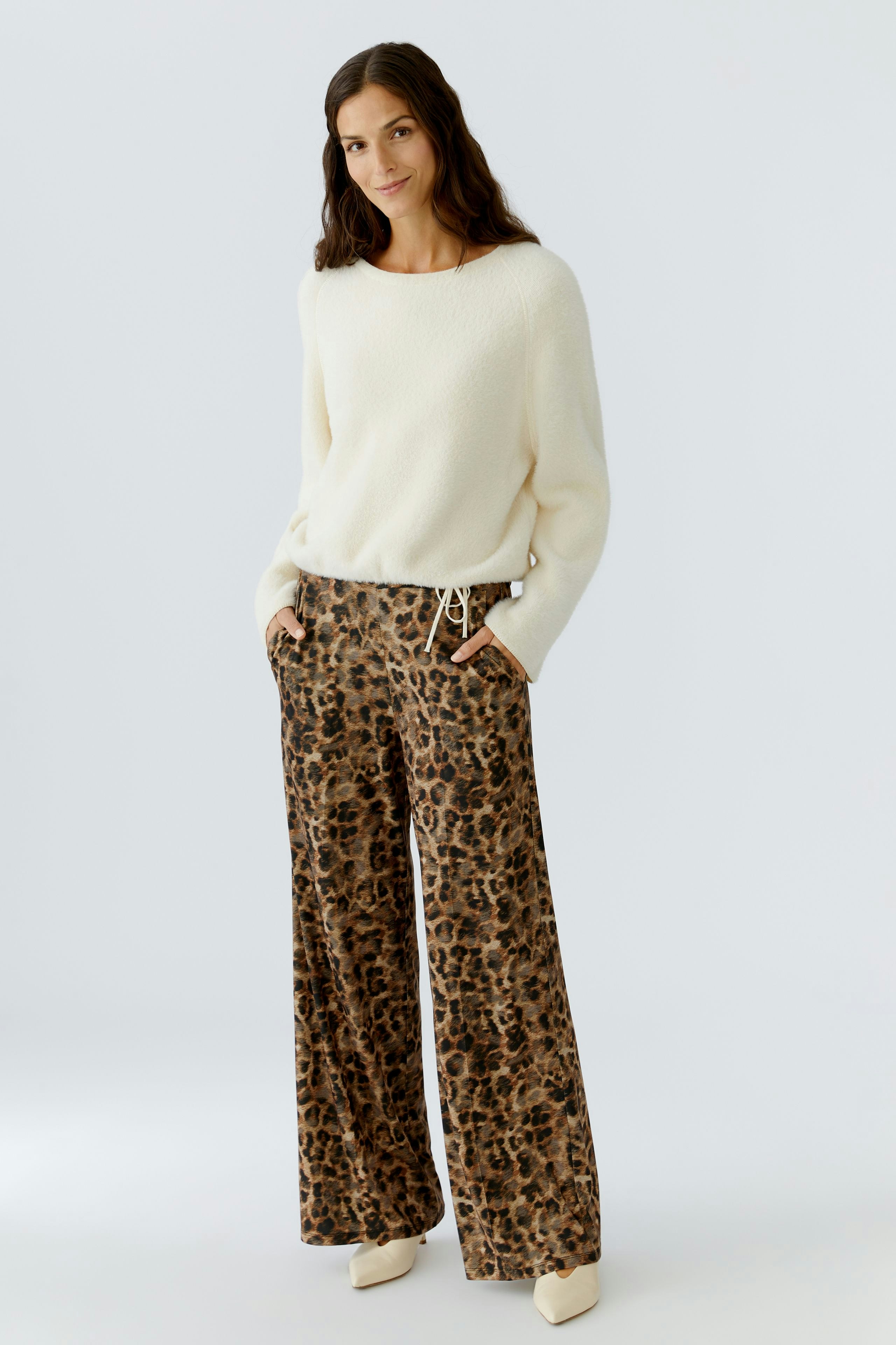 Damen-Pullover in Creme: Frau trägt einen weichen, lässigen Pullover mit weitem Schnitt.