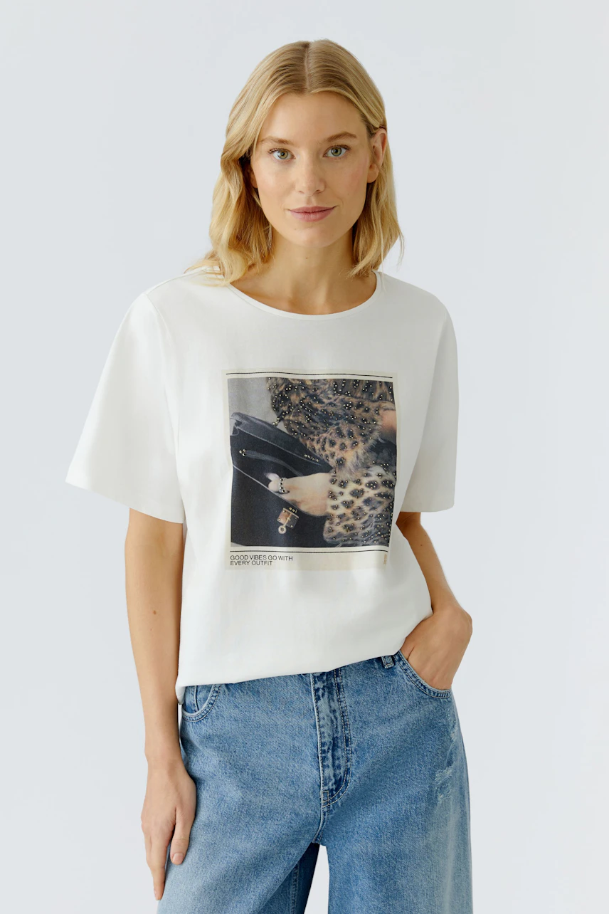 Damen-T-Shirt: Frau in weißem T-Shirt mit Leopardenmotiv und lässigen Jeans.