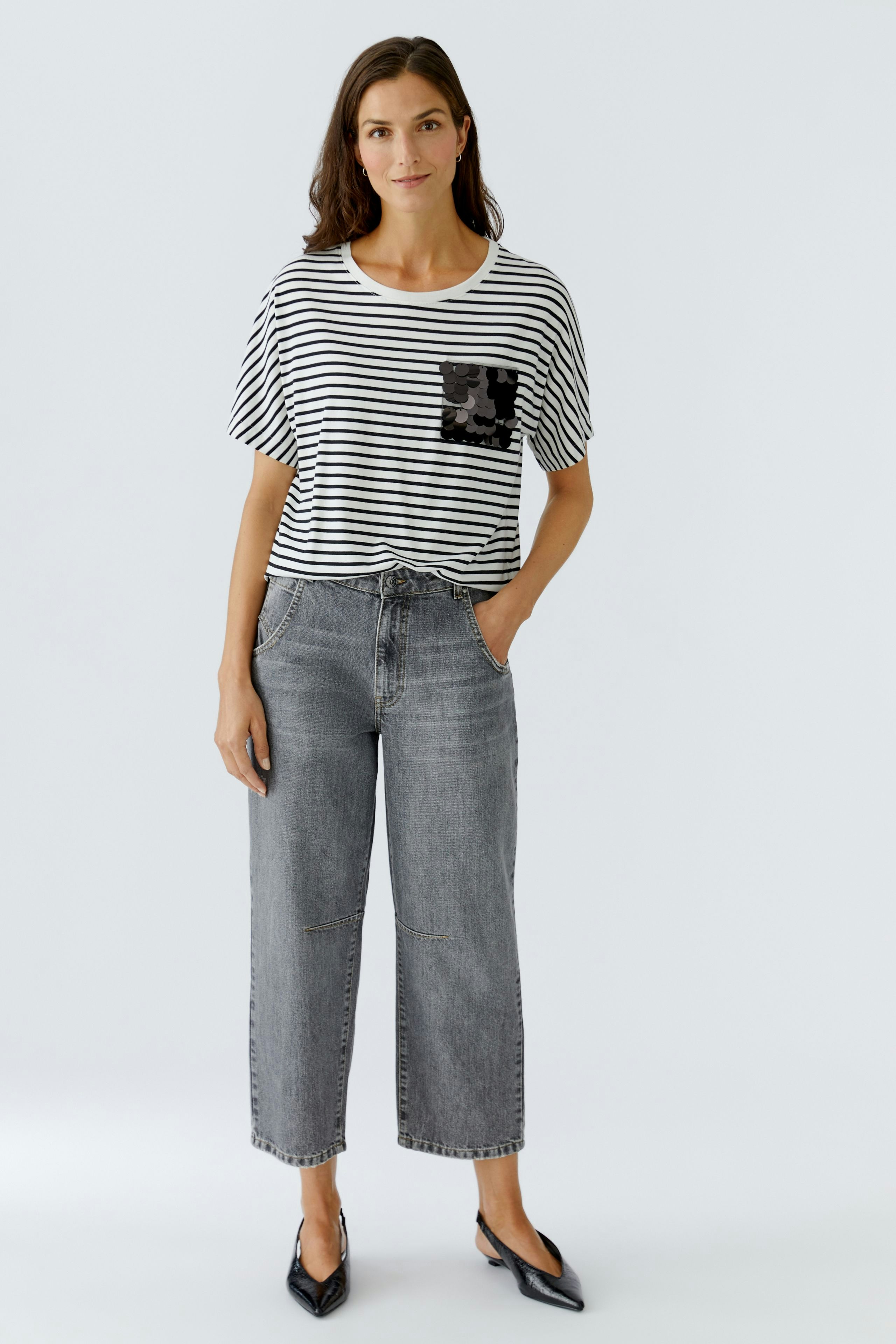 Casual women's T-shirt: Woman in a striped tee with a pocket detail, paired with relaxed-fit jeans.