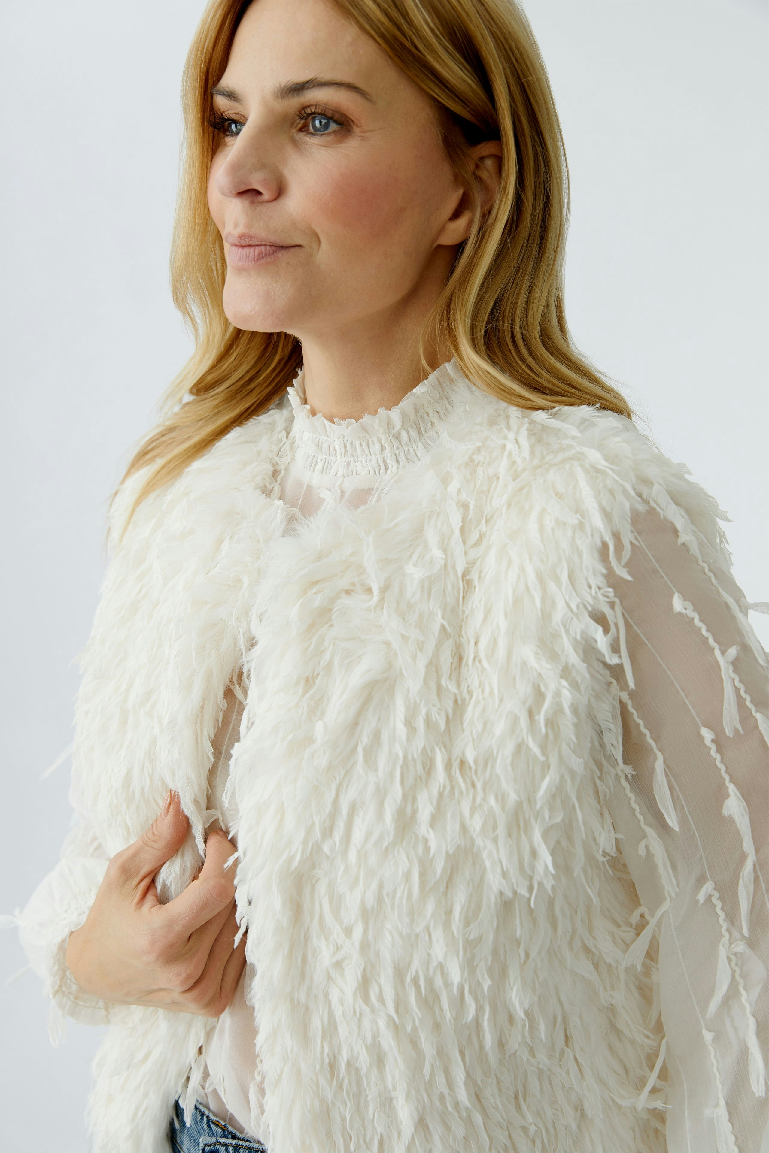 Moderne Damen-Weste: Frau in einer weißen, flauschigen Weste mit lässigem Look.