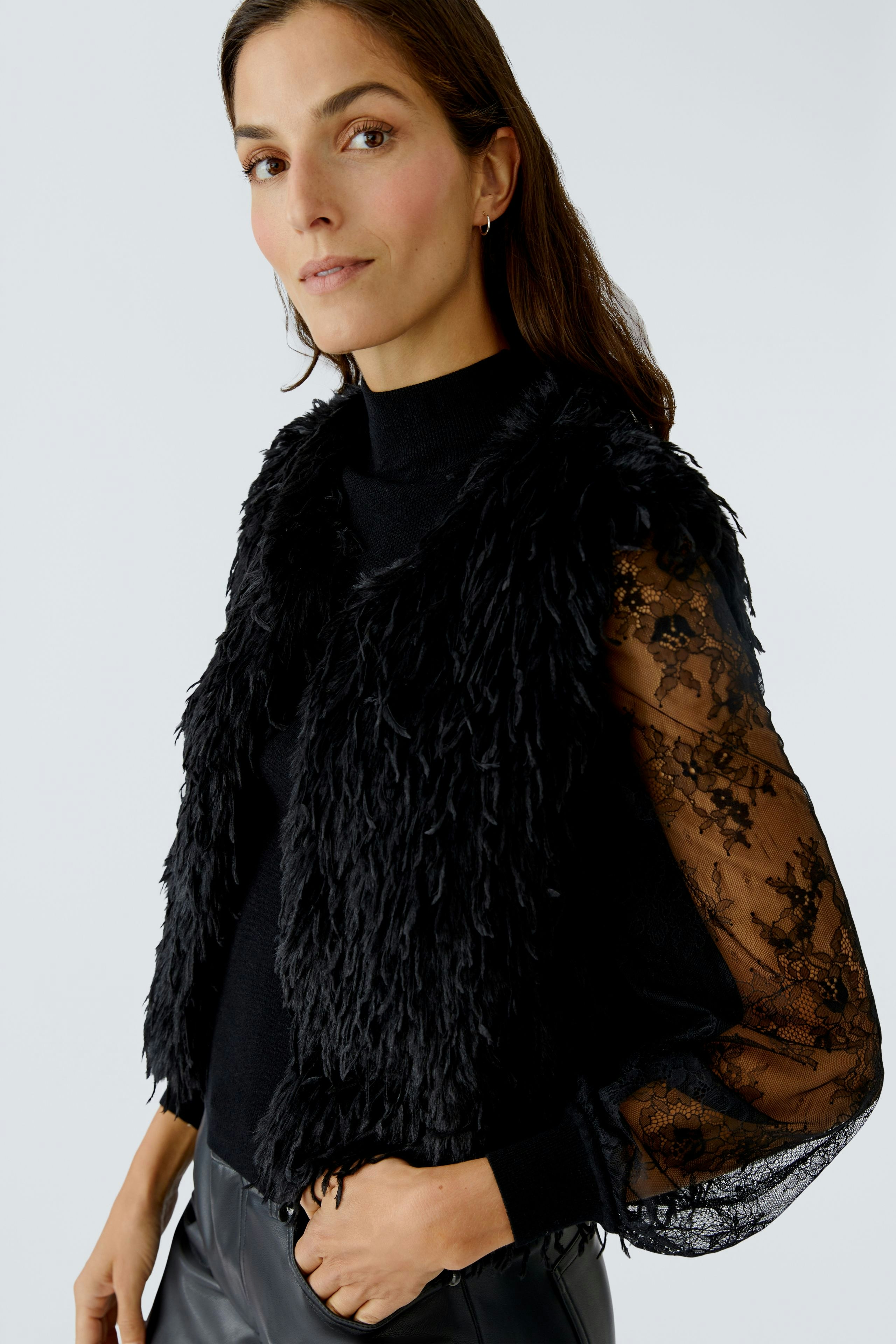 Stylish women's vest: A woman in a black fluffy vest over a black top, exuding a casual vibe.