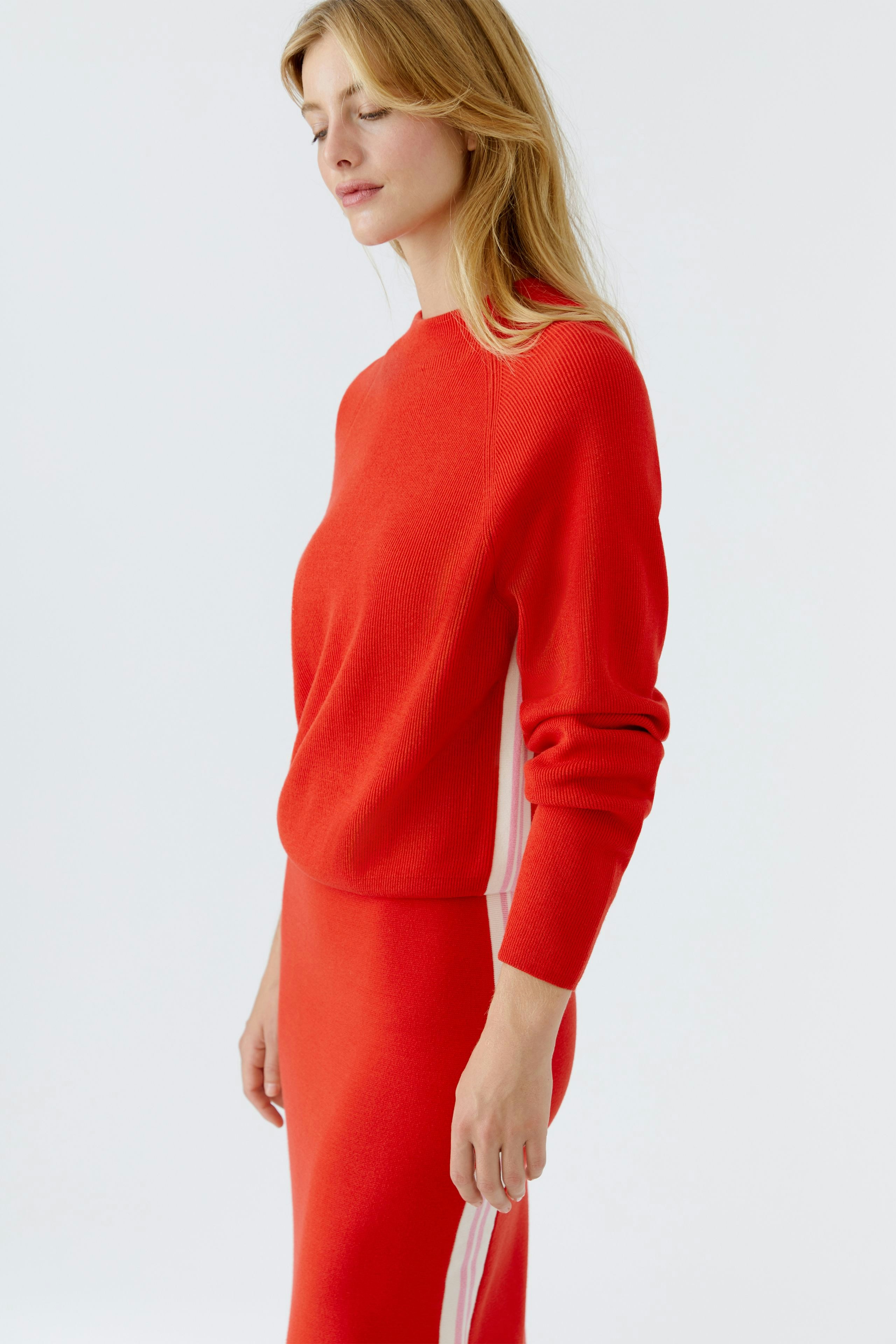 Roter Damen-Pullover: Frau trägt einen lässigen Pullover mit sportlichen Details.