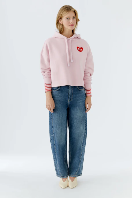 Bequemer Damen-Hoodie in zartem Rosa mit rotem Herz-Logo. Ideal für lässige Outfits.