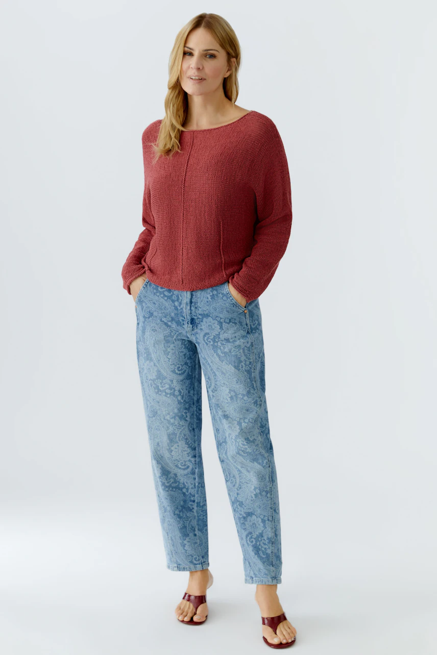 Bequemer Damen-Pullover in Rot: Frau trägt lässigen Pullover mit lockerer Passform und Jeans.