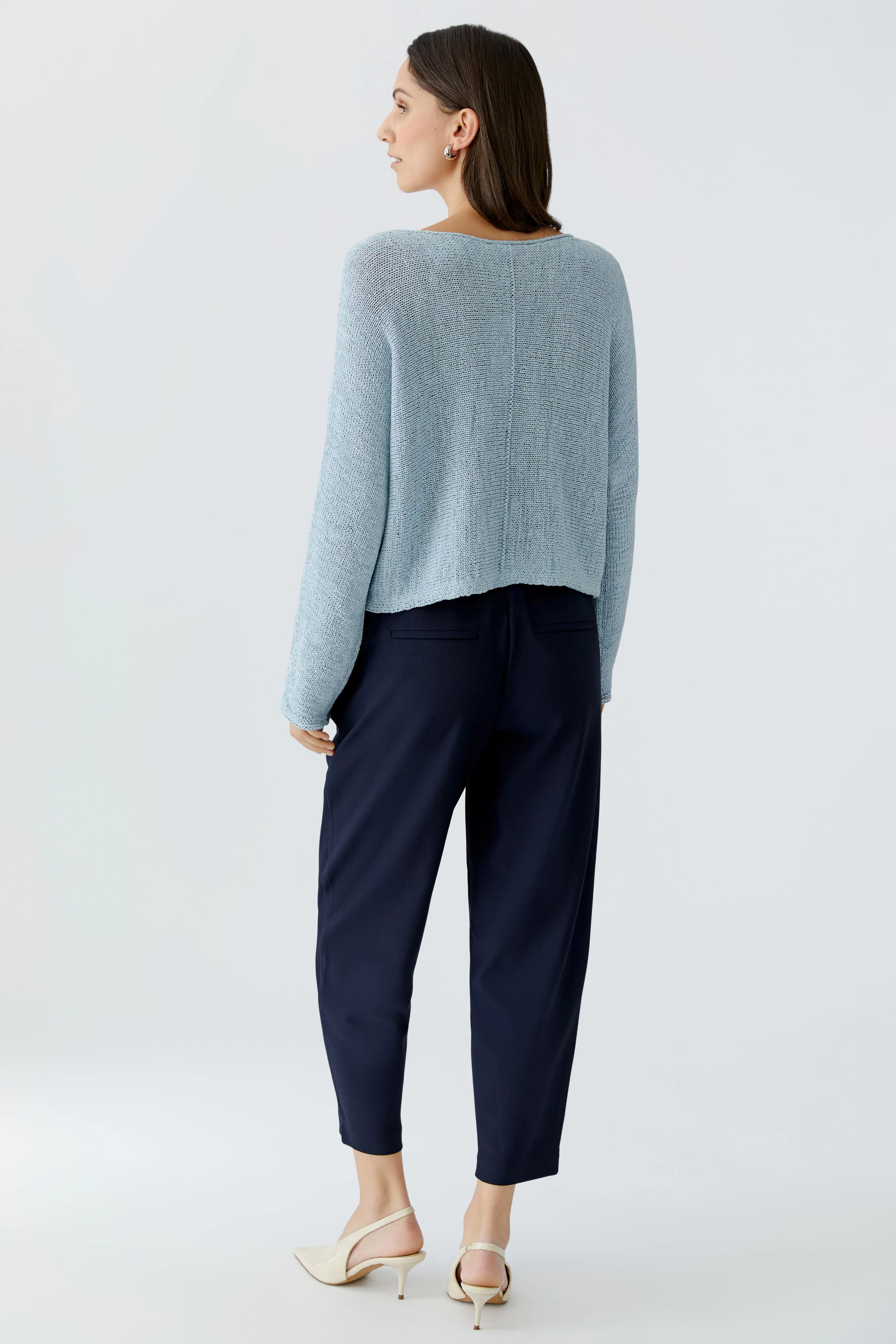 Damen-Pullover: Frau in hellblauem, lässigem Strickpullover mit lockerer Passform von hinten.