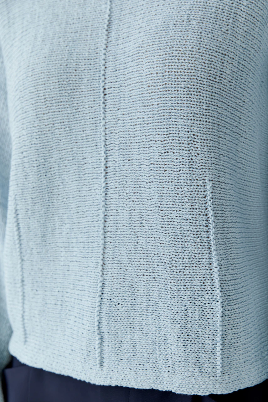 Light blue pullover: Close-up of a woman's casual knit pullover with a relaxed fit.