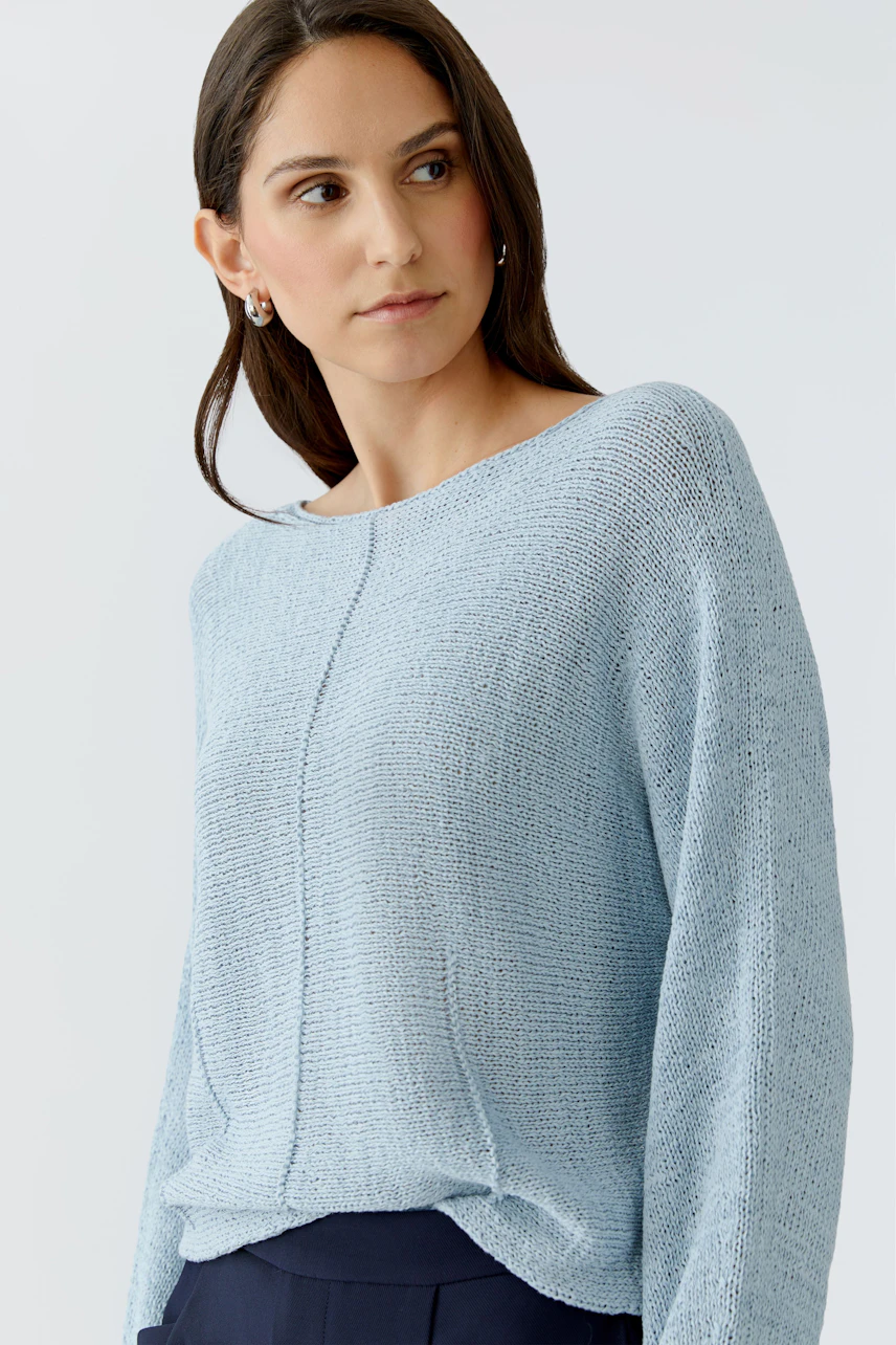 Casual women's pullover: Young woman in a light blue knit pullover with a relaxed fit.