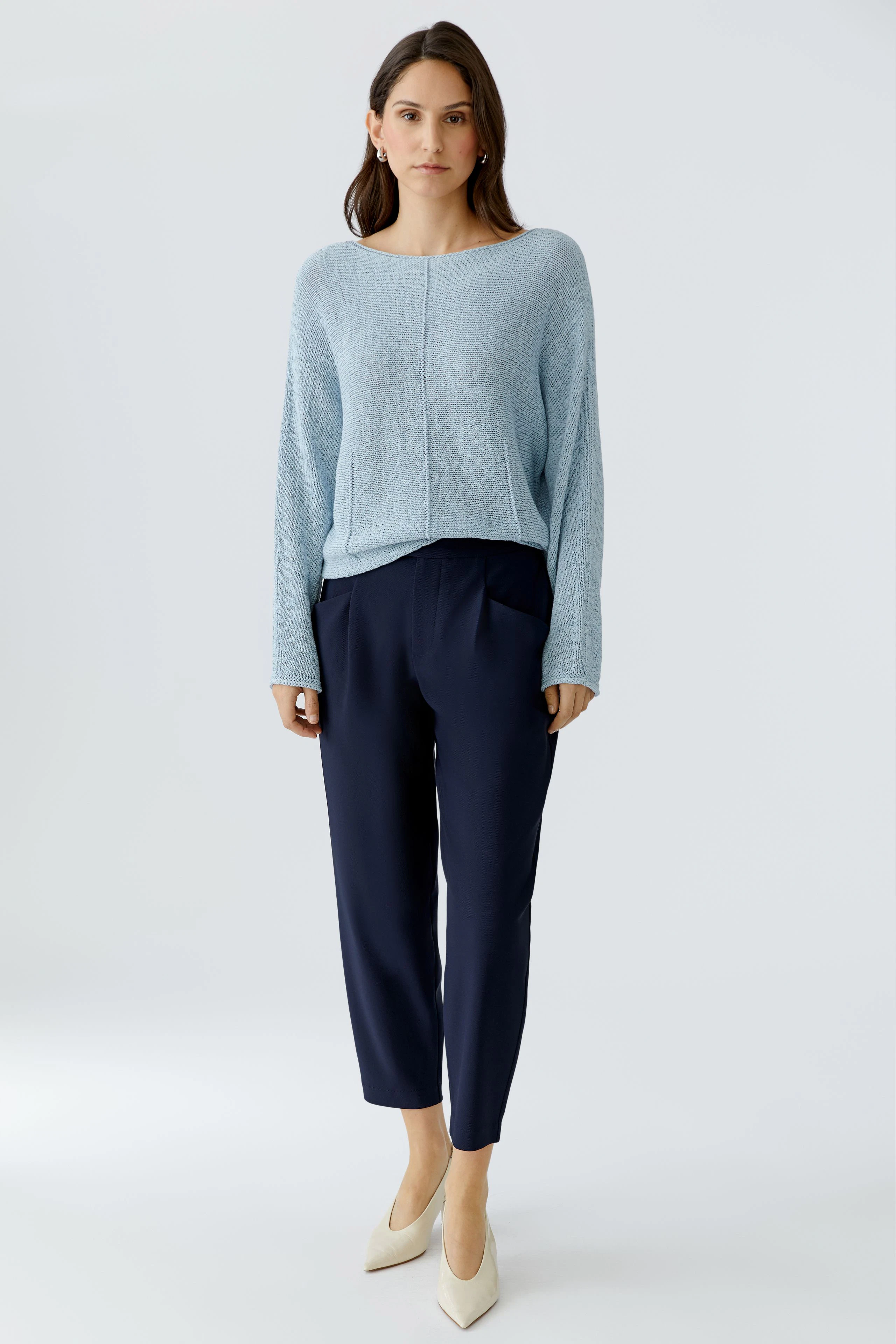 Casual women's pullover: Woman in a light blue pullover paired with navy trousers, exuding a relaxed vibe.
