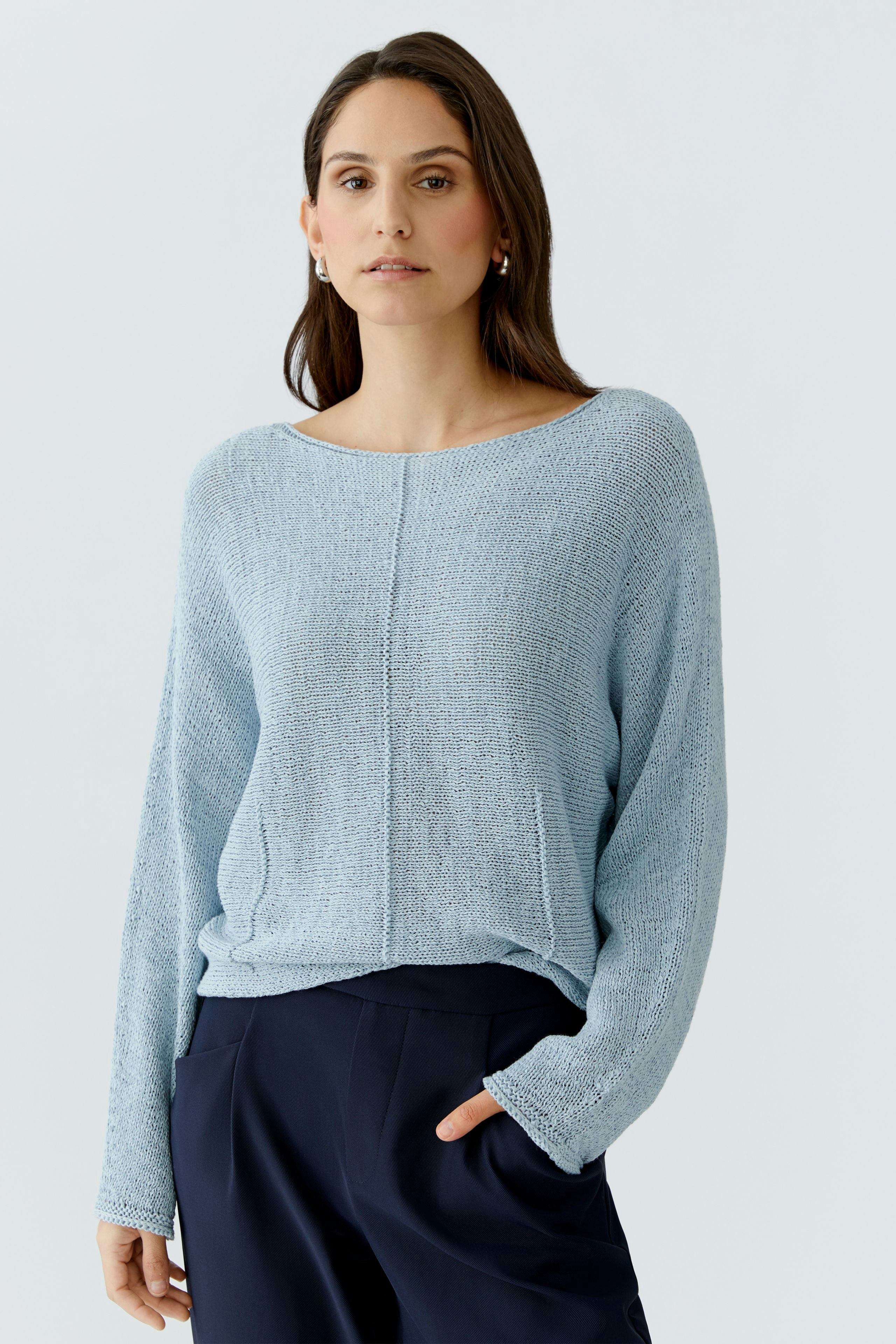 Lässiger Damen-Pullover: Frau in hellblauem Strickpullover mit lockerer Passform und langen Ärmeln.