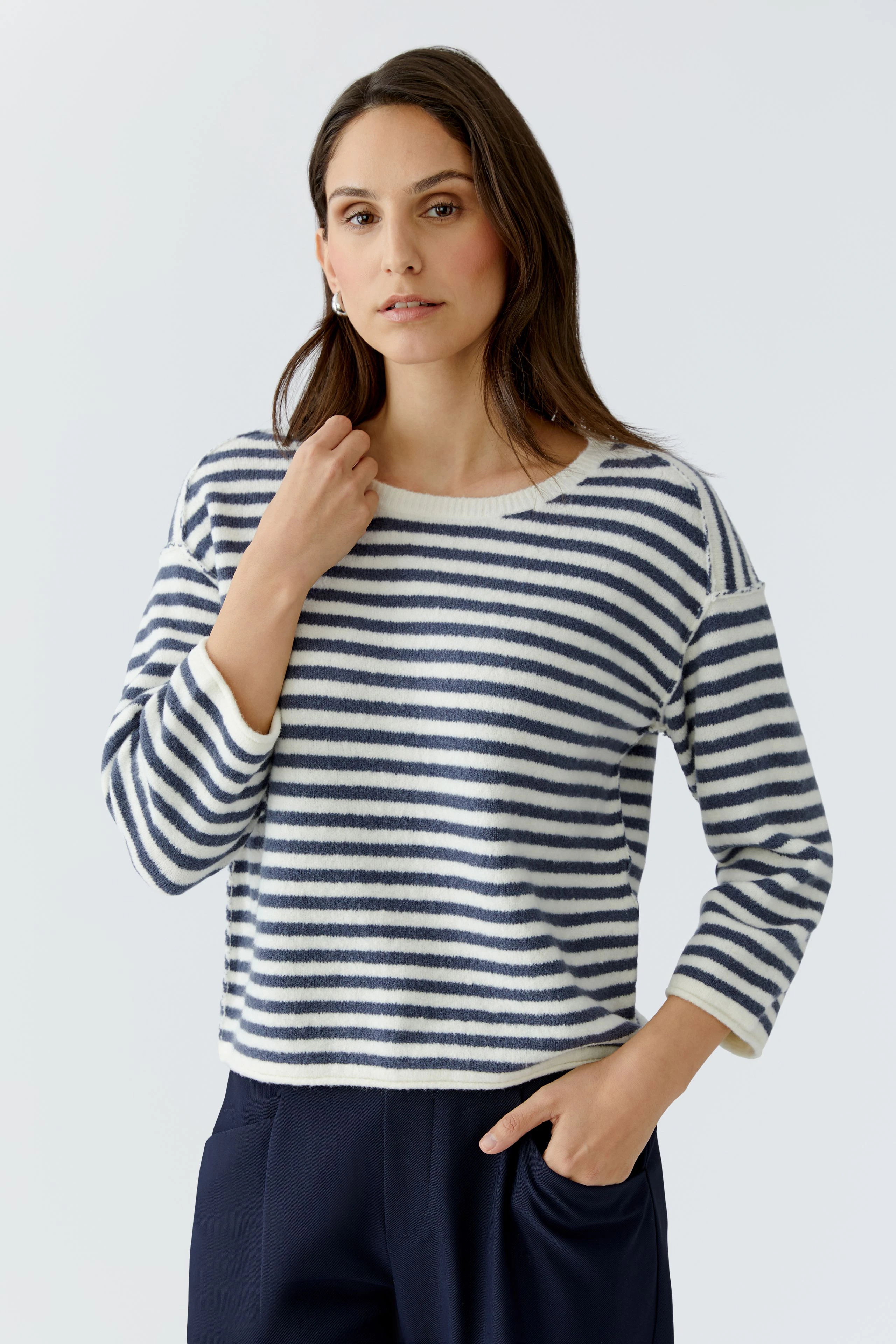 Casual women's pullover: A woman in a striped pullover with three-quarter sleeves poses confidently.