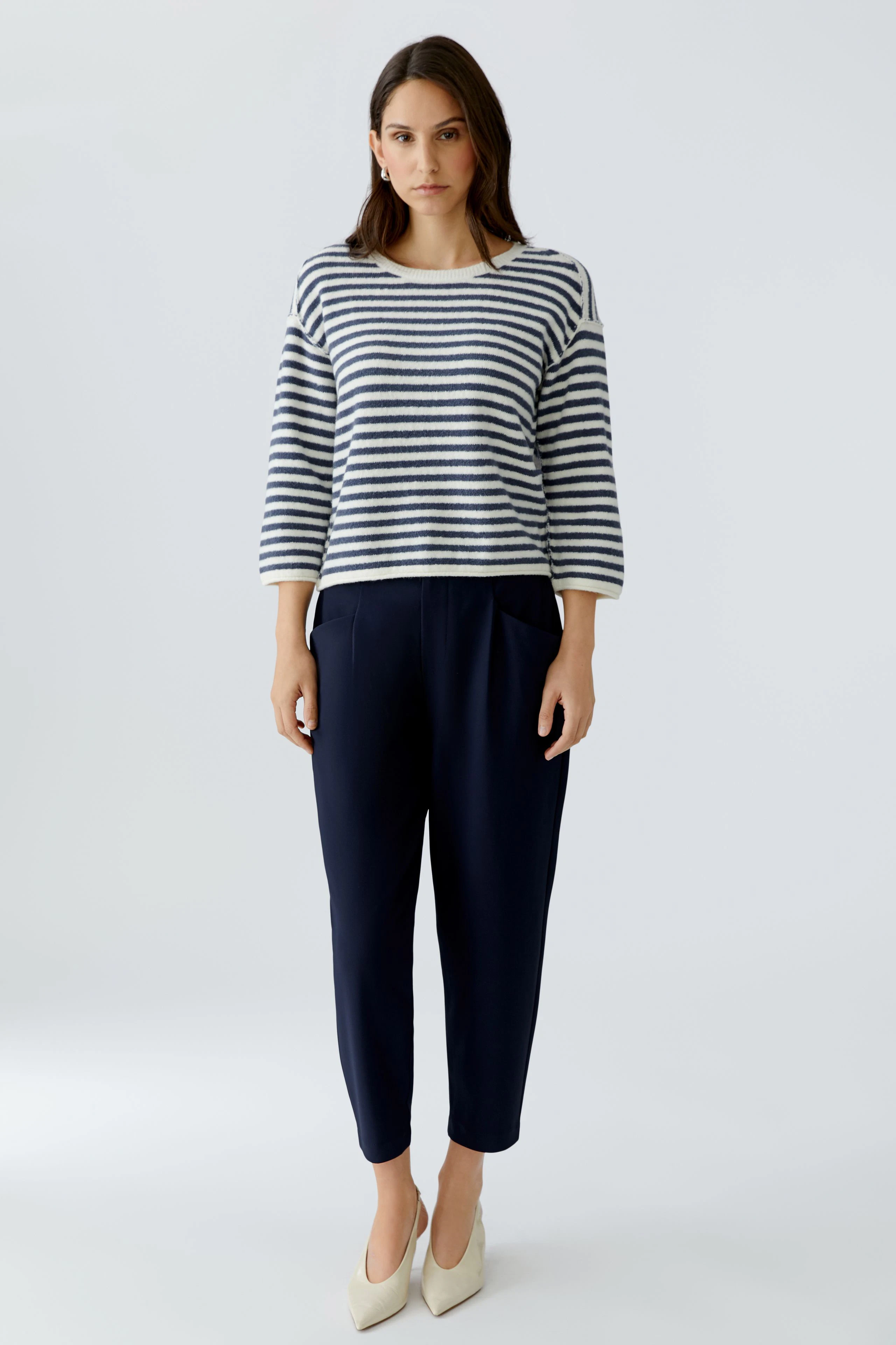 Casual women's pullover: A woman in a striped pullover with three-quarter sleeves and navy pants.