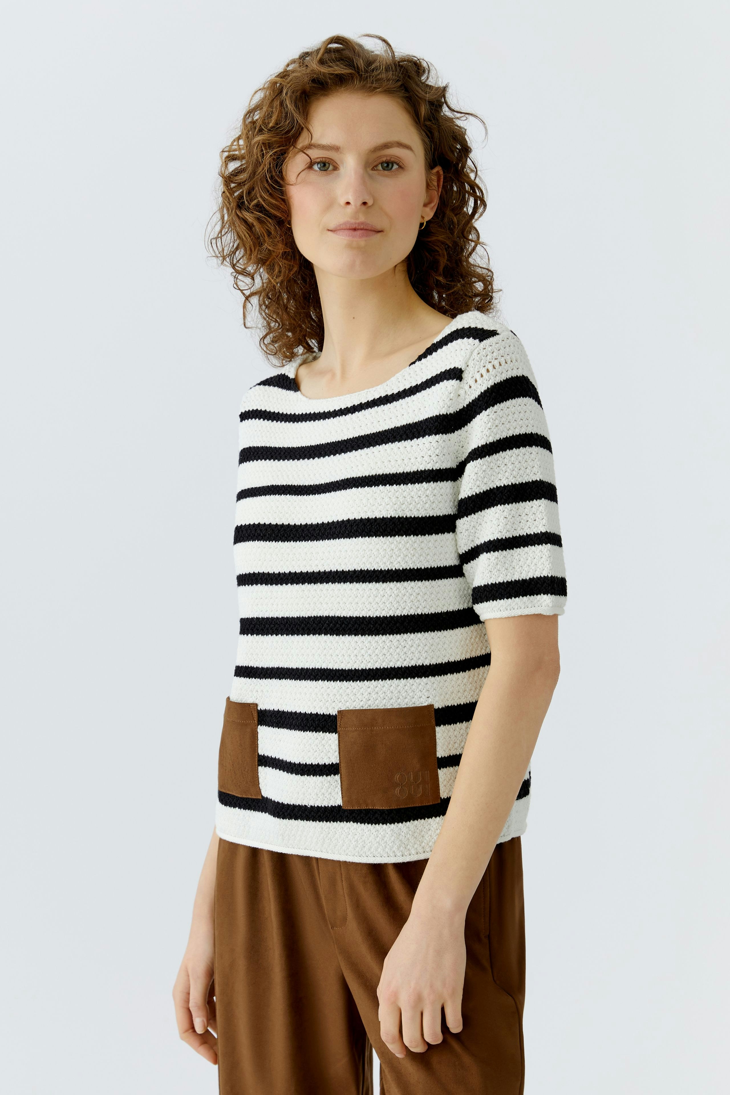 Casual women's pullover: A woman in a striped pullover with brown pockets, styled with relaxed pants.
