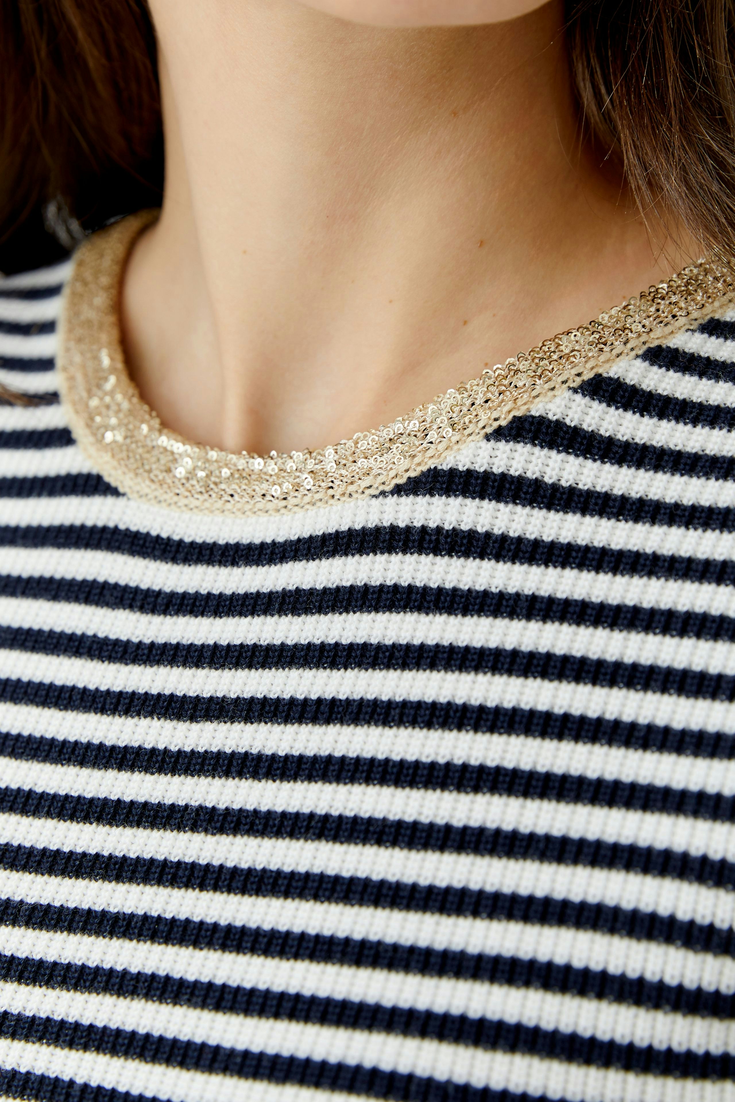 Casual women's pullover: Close-up of a striped pullover with a shiny neckline detail.