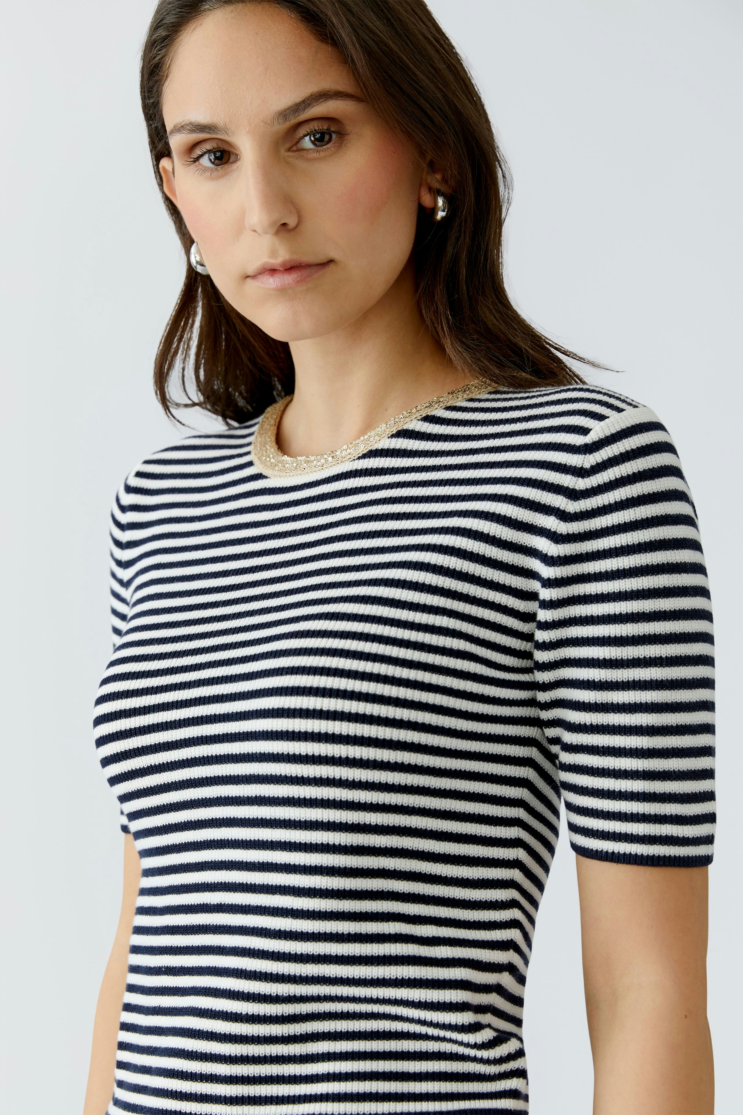 Casual women's pullover: Young woman in a striped pullover with short sleeves, looking confidently at the camera.