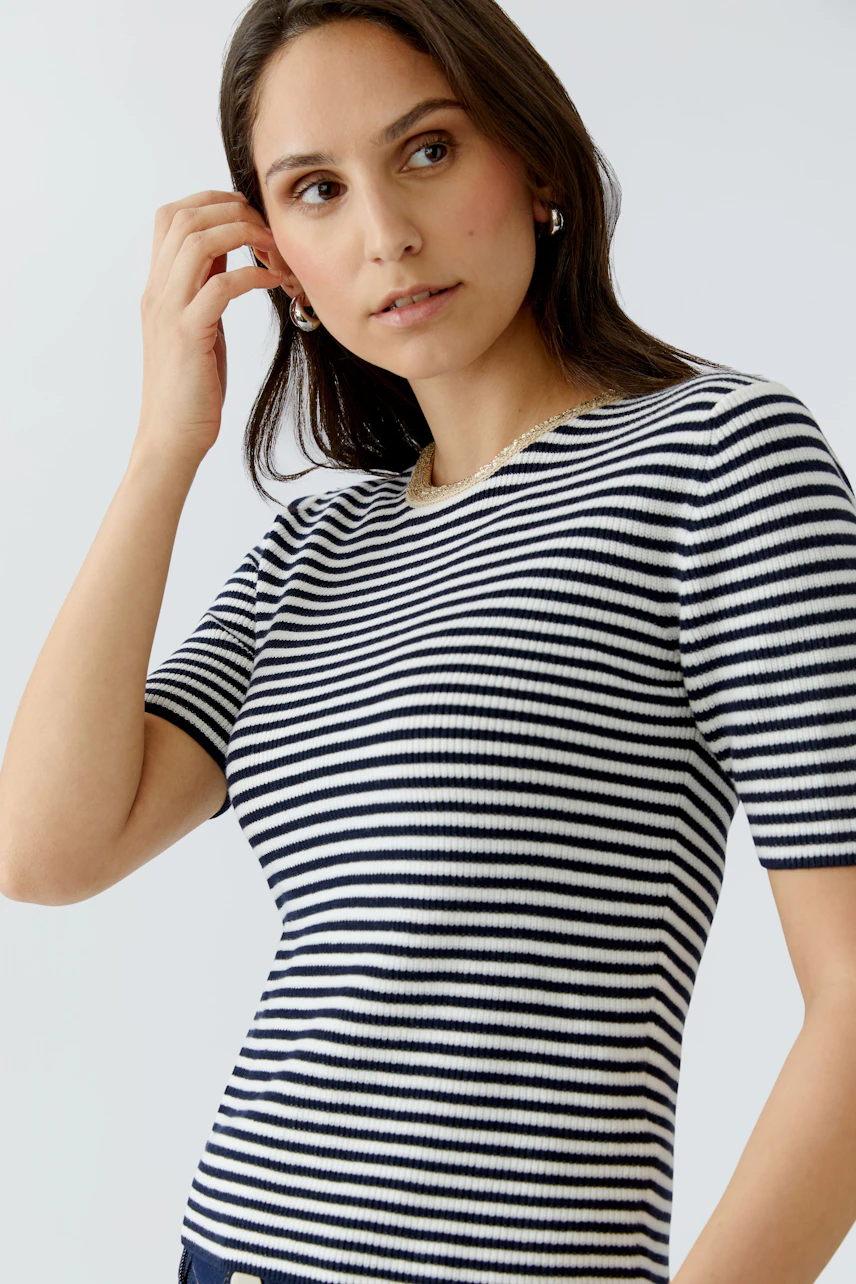 Damen-Pullover: Frau in gestreiftem, kurzärmligem Pullover mit Rundhalsausschnitt blickt nachdenklich.