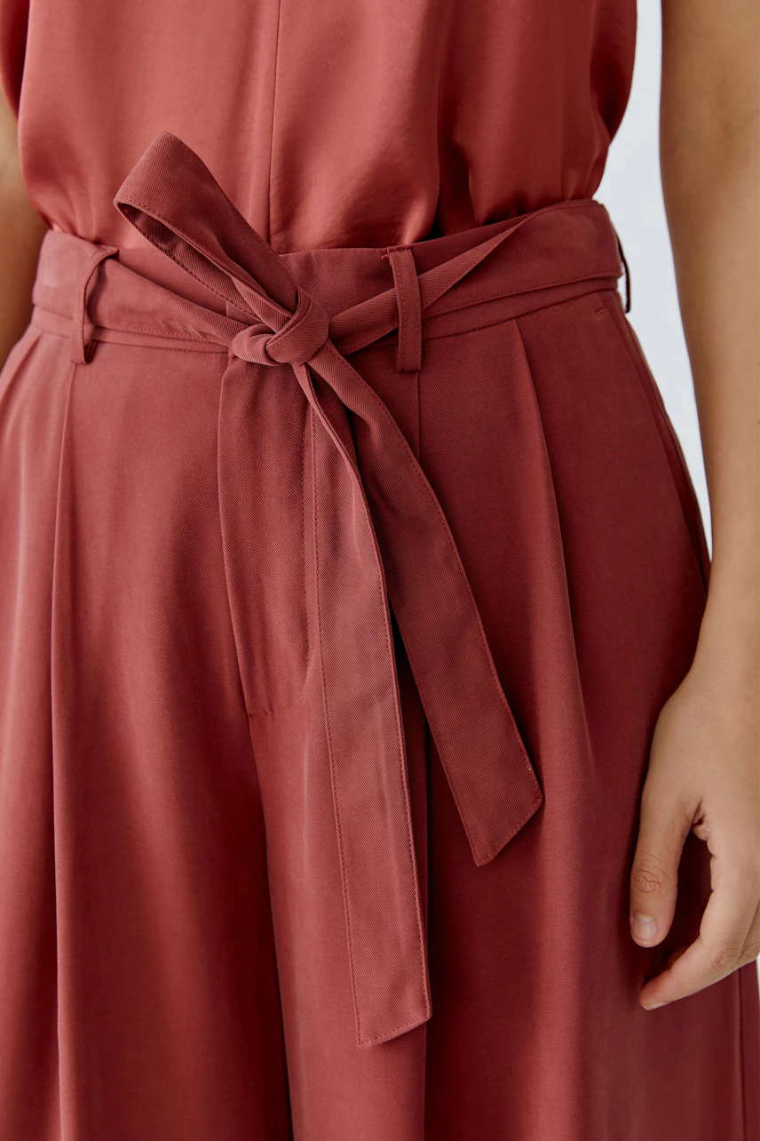 Stylish women's pleated trousers with a tied belt, perfect for casual wear.