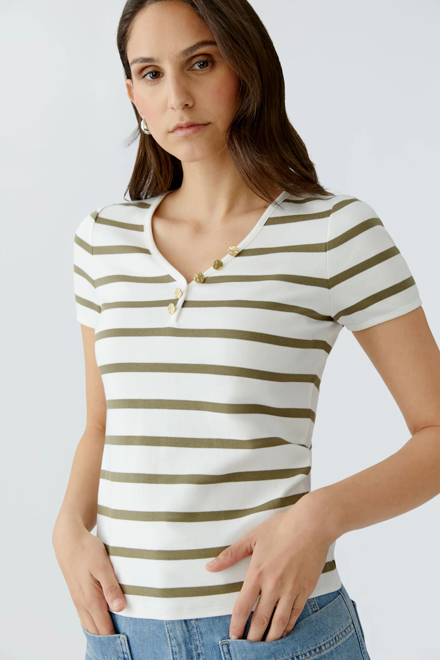 Damen-T-Shirt: Junge Frau in gestreiftem Shirt mit Knöpfen, lässig und modern.