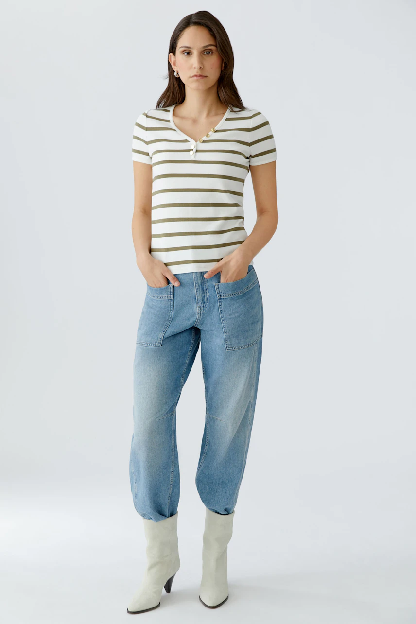 Bequemes Damen-T-Shirt: Junge Frau in gestreiftem T-Shirt mit V-Ausschnitt und lässigen Jeans.