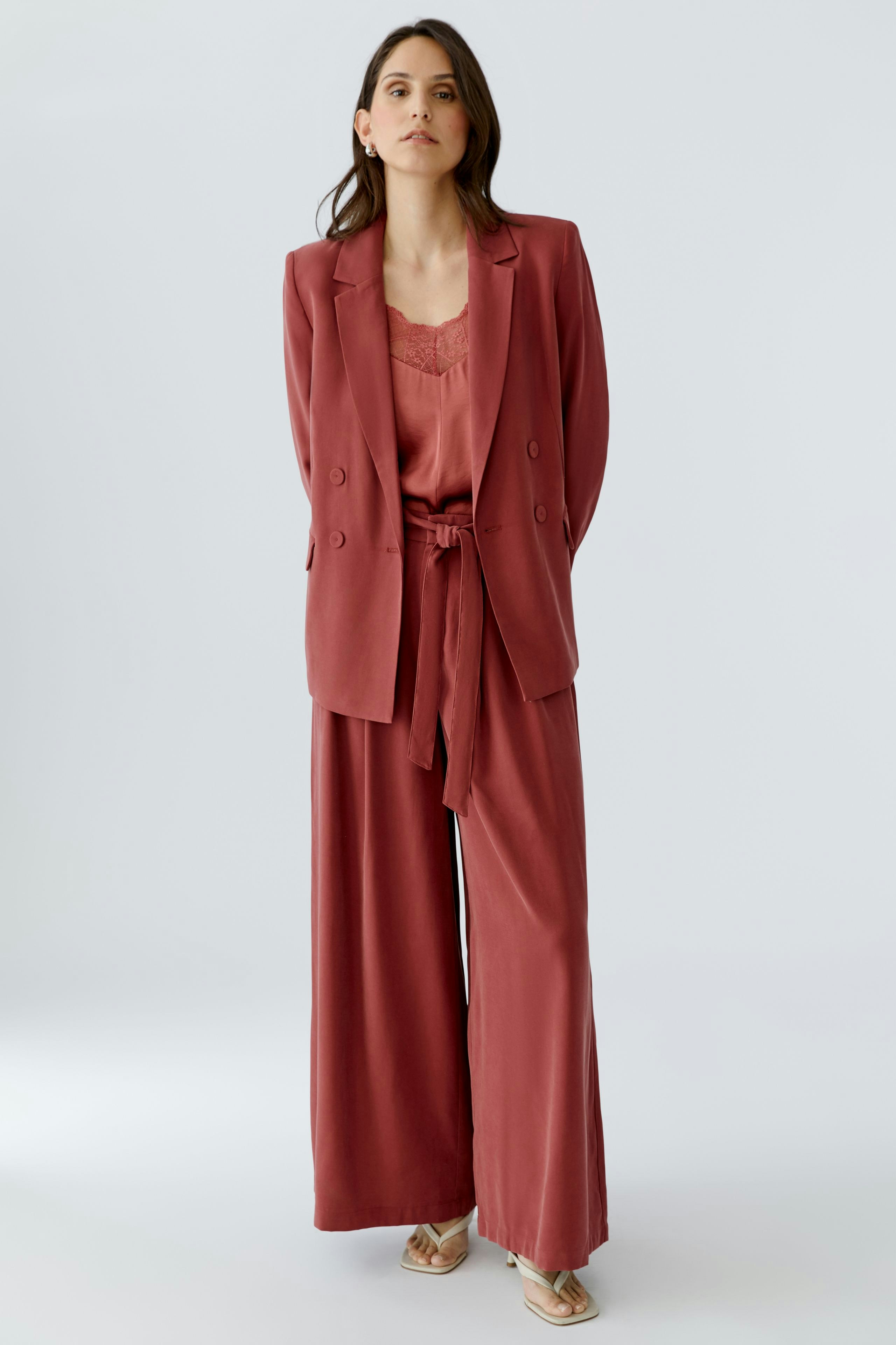 Modischer Damen-Blazer: Frau in einem rosafarbenen Blazer mit lässigem Schnitt und passender Hose.