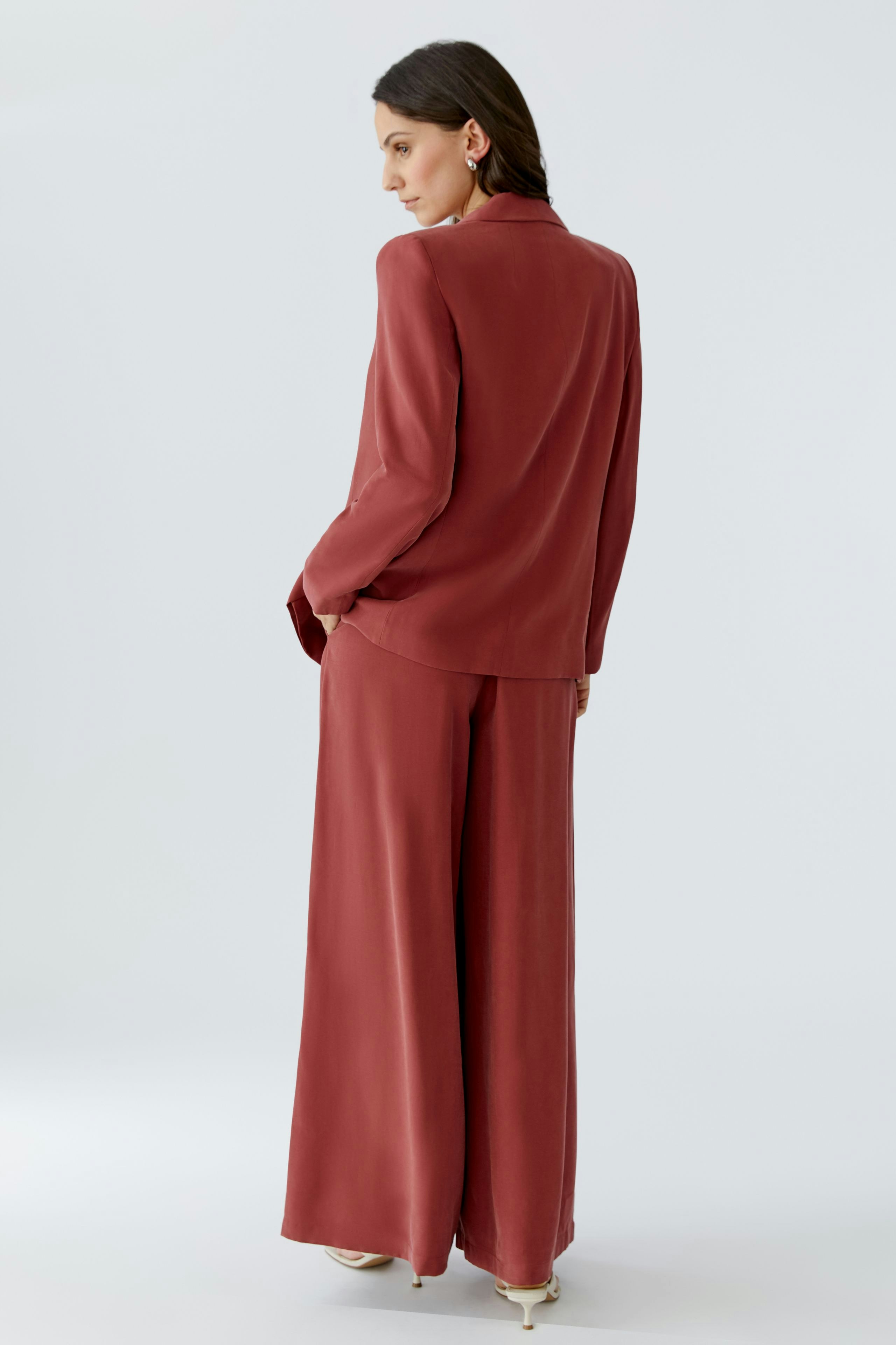 Damen-Blazer in Rot: Frau mit lässigem Schnitt, der locker sitzt und vielseitig kombinierbar ist.