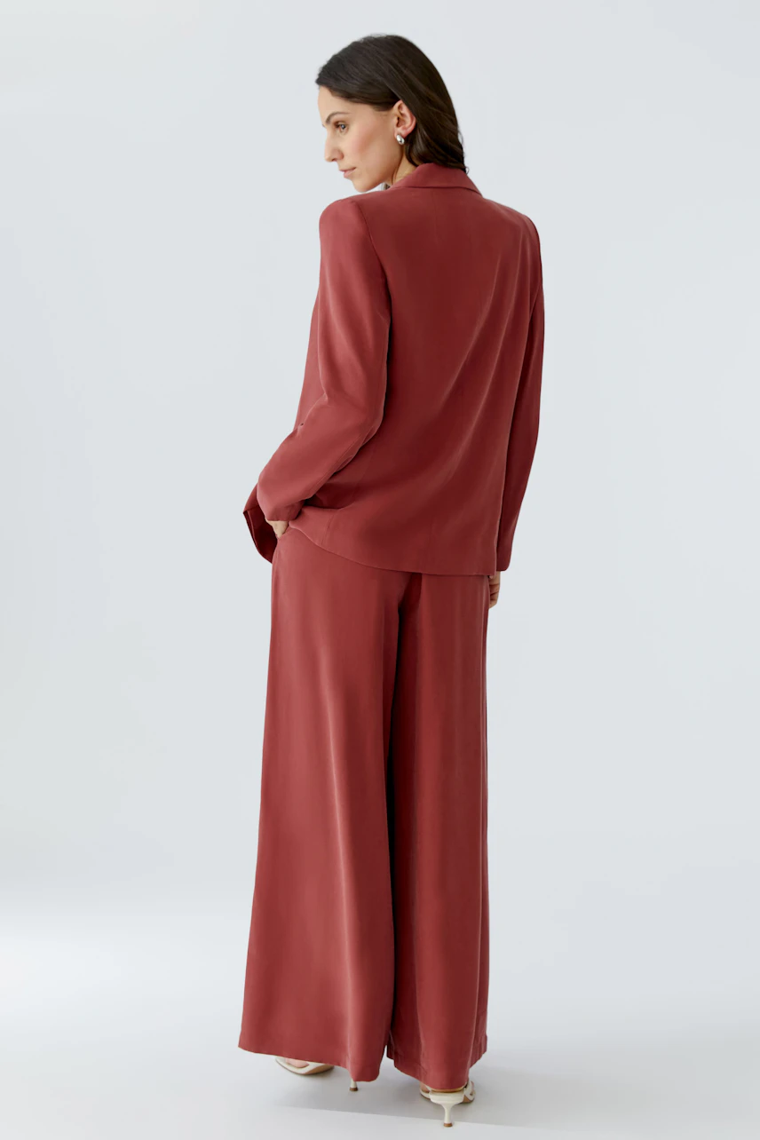 Damen-Blazer in Rot: Frau mit lässigem Schnitt, der locker sitzt und vielseitig kombinierbar ist.