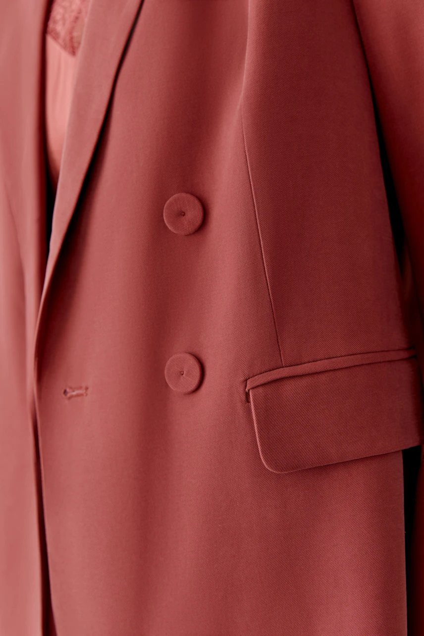 Modischer Damen-Blazer in warmem Rot mit doppelter Knopfleiste und lässigem Schnitt.
