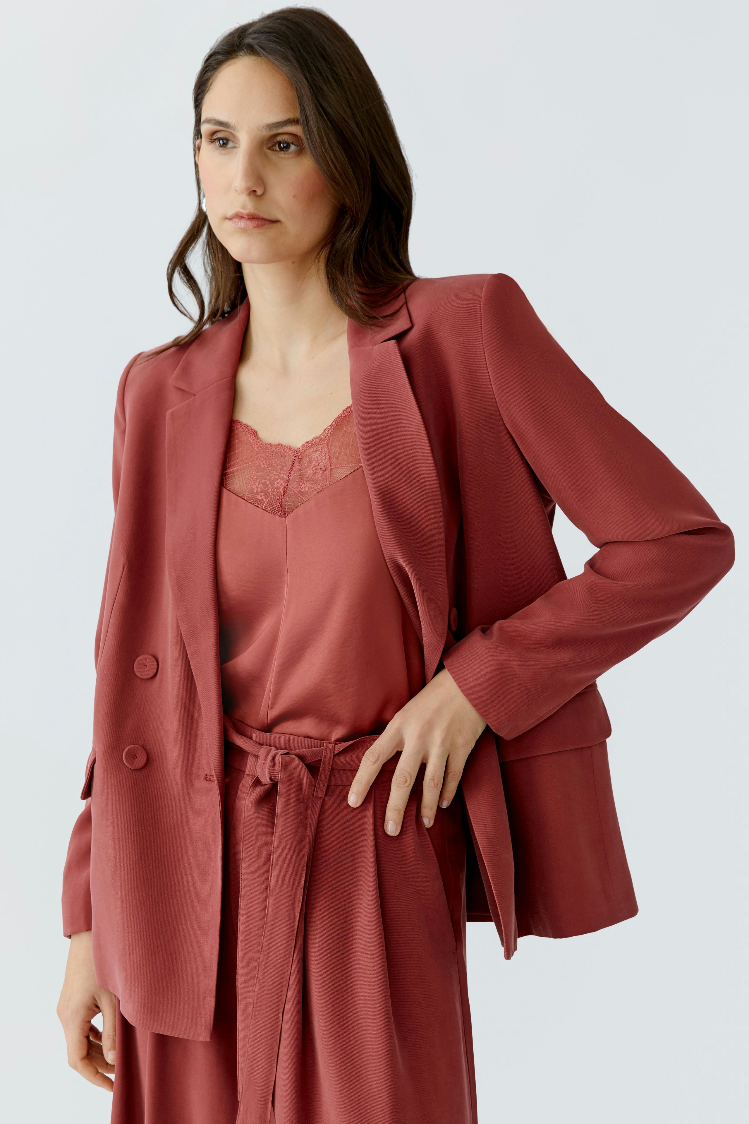 Damen-Blazer in Rosé: Frau trägt einen lässigen Blazer über einem Top und kombiniert mit einer Hose.