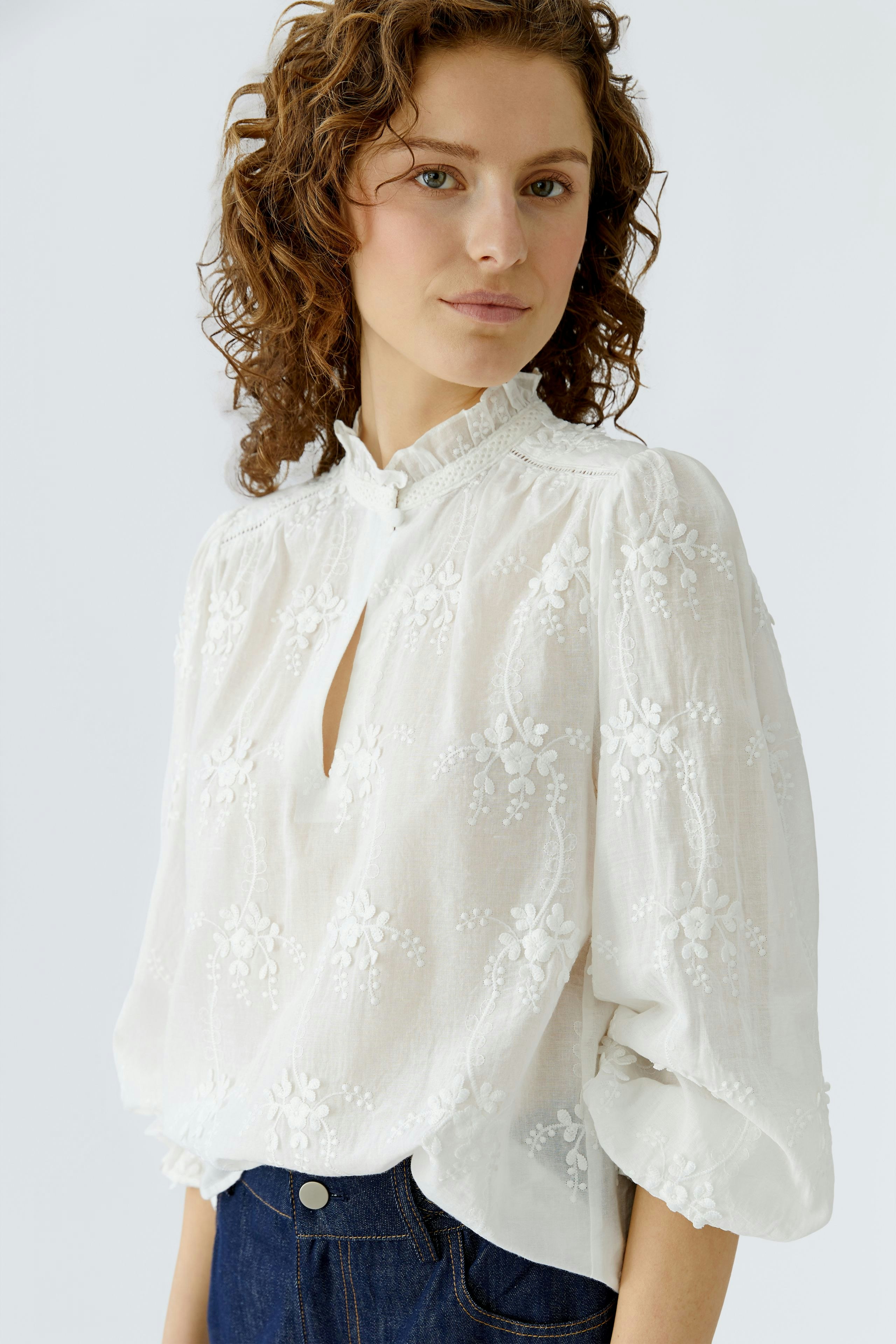 Lightweight women's blouse with floral embroidery, featuring a keyhole neckline and relaxed fit.