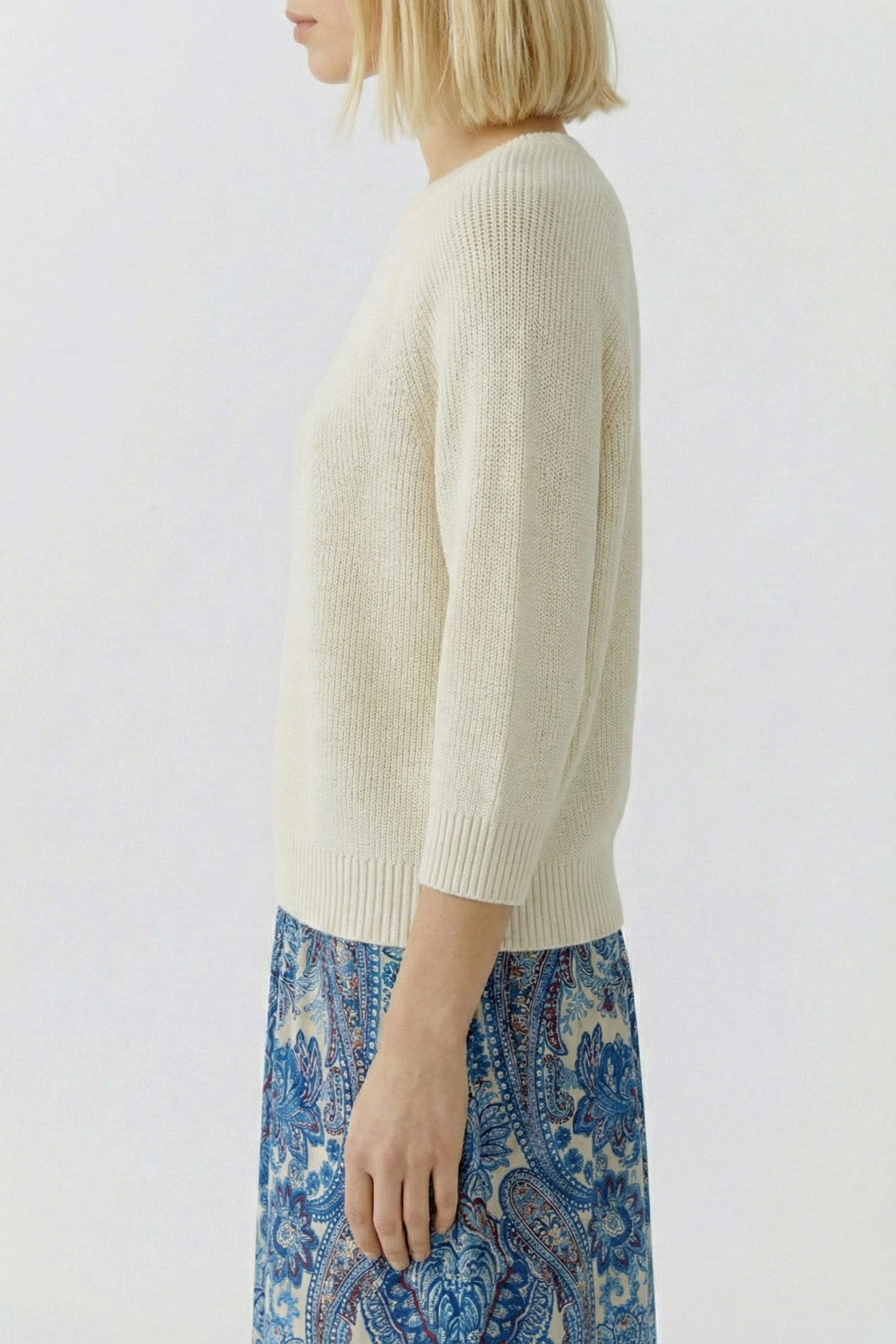 Casual women's pullover: Young woman in a cream-colored knit pullover with a relaxed fit.