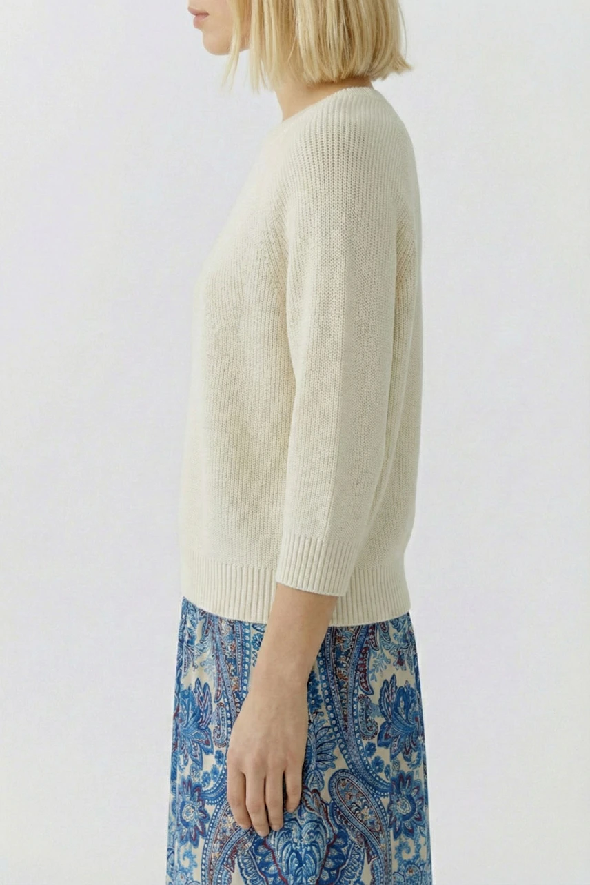 Casual women's pullover: Young woman in a cream-colored knit pullover with a relaxed fit.