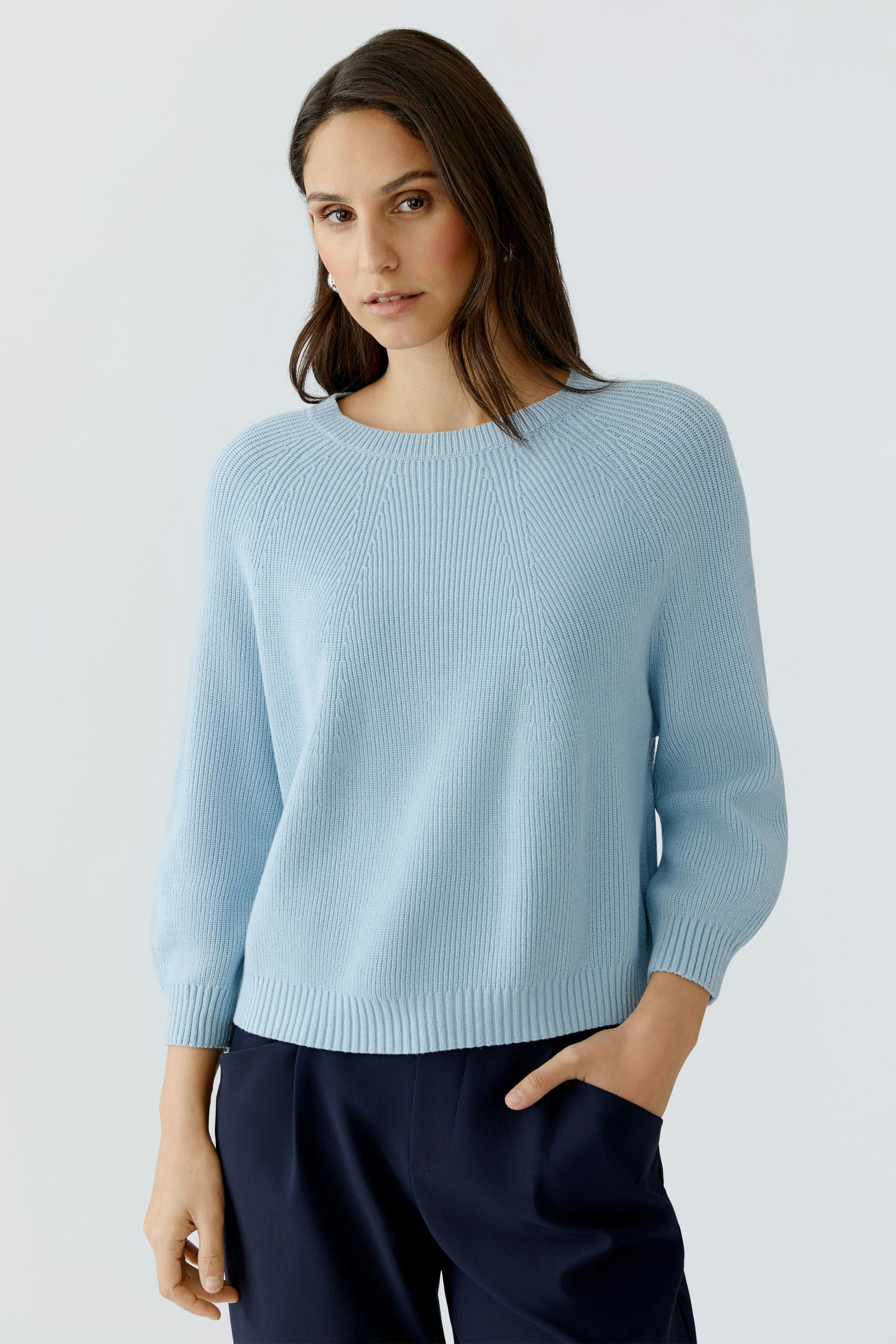 Damen-Pullover: Frau in hellblauem, lässigem Strickpullover mit Rundhalsausschnitt und 3/4-Ärmeln.