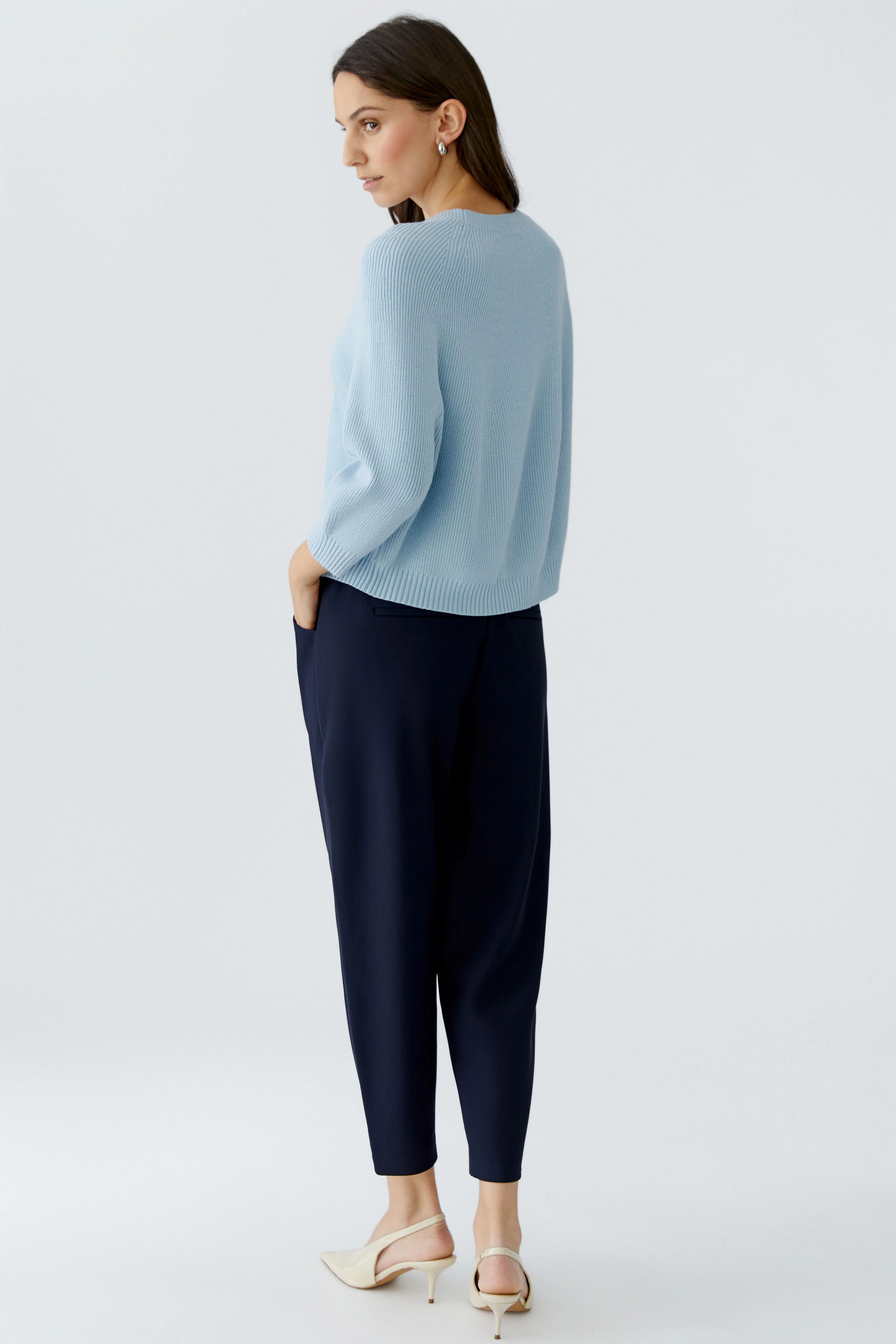 Damen-Pullover: Frau in hellblauem Strickpullover mit lockerer Passform und bequemen Hosen.