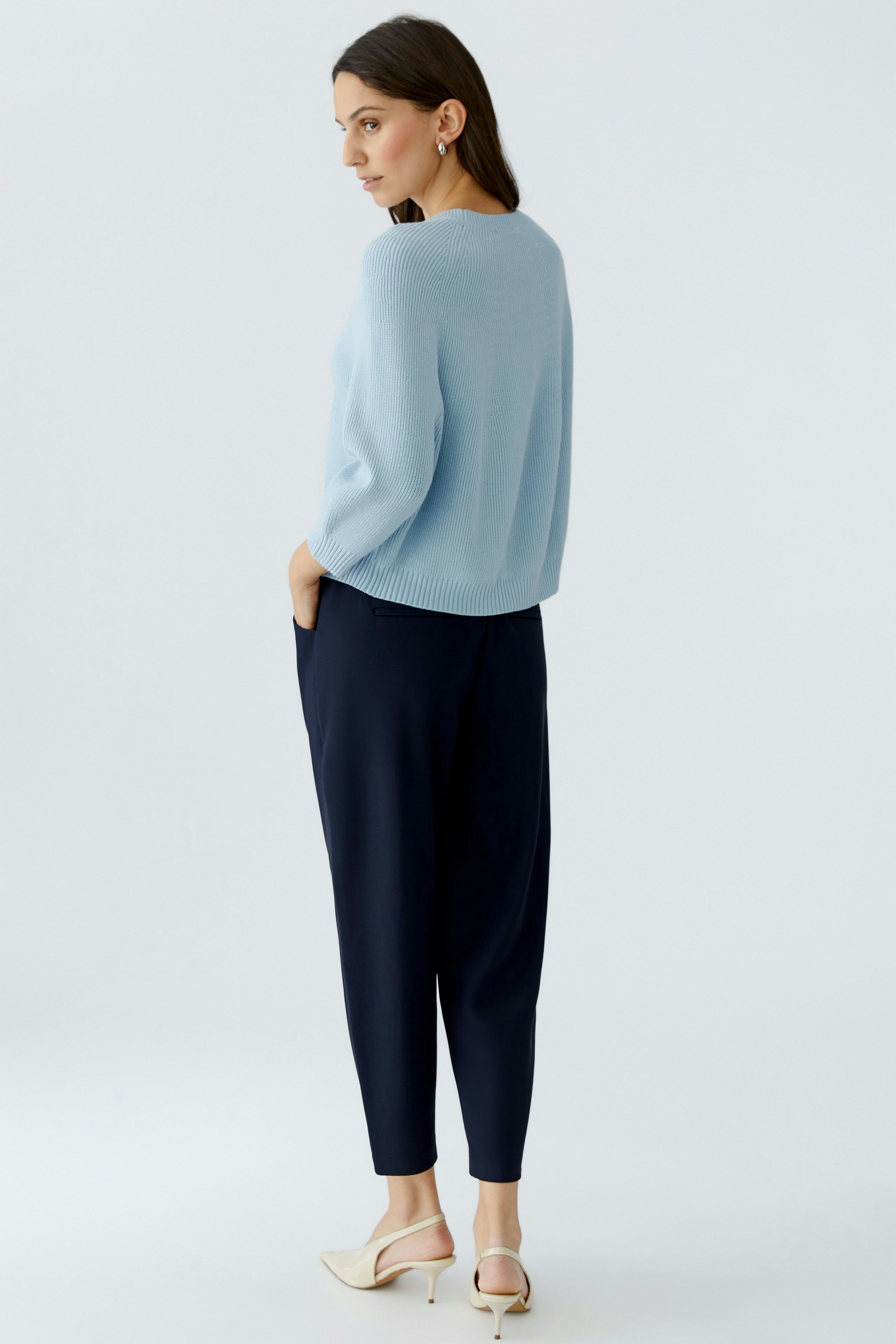 Damen-Pullover: Frau in hellblauem Strickpullover mit lockerer Passform und bequemen Hosen.