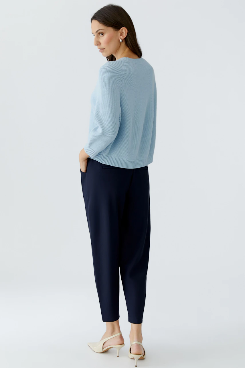 Damen-Pullover: Frau in hellblauem Strickpullover mit lockerer Passform und bequemen Hosen.