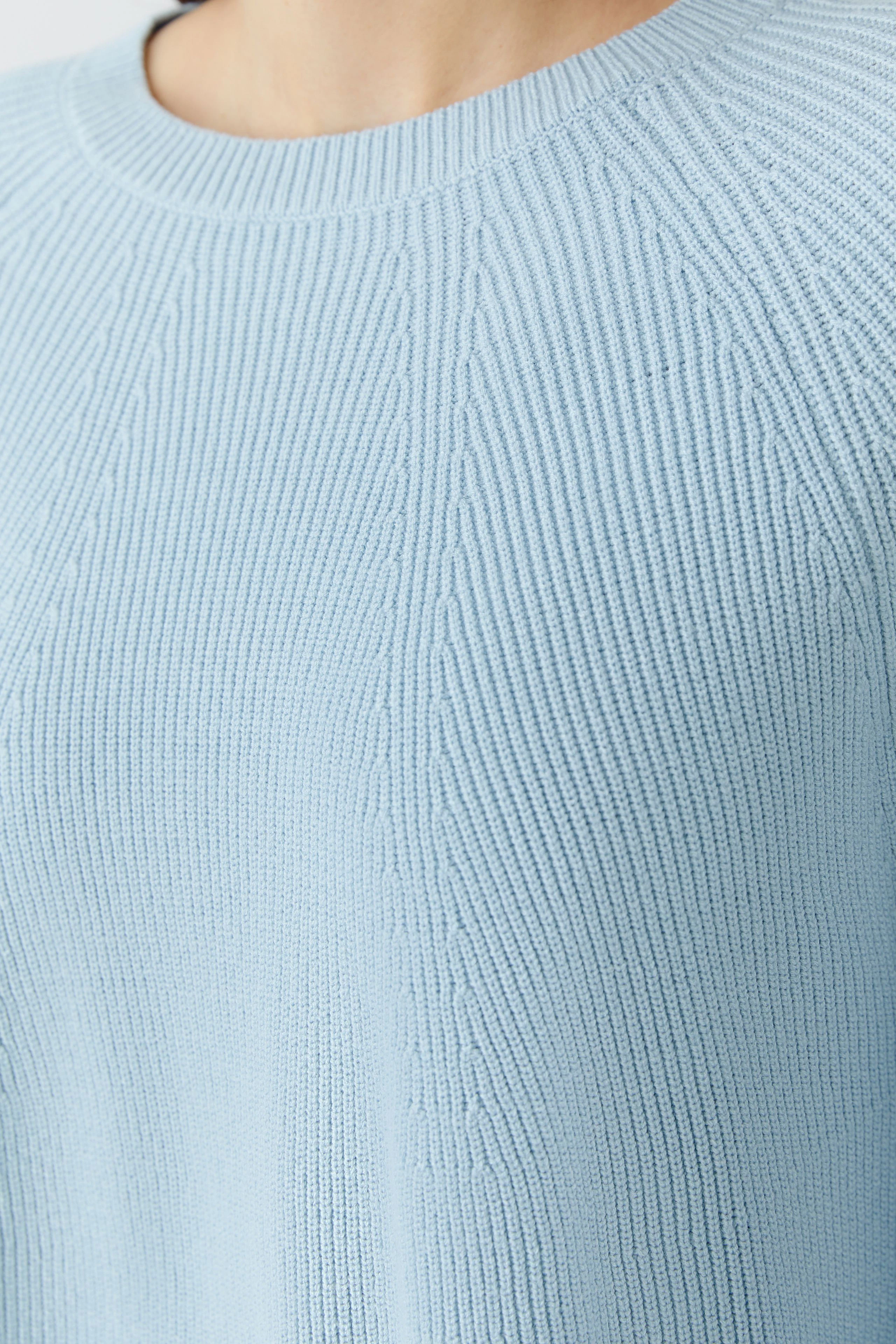 Helle Damen-Pullover: Frau trägt einen blauen, strukturierten Strickpullover mit Rundhalsausschnitt.