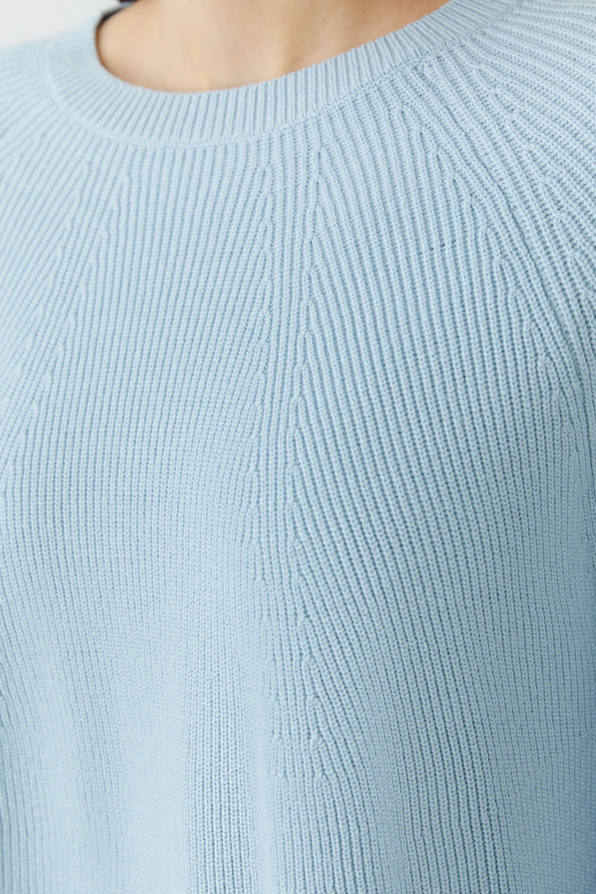 Helle Damen-Pullover: Frau trägt einen blauen, strukturierten Strickpullover mit Rundhalsausschnitt.