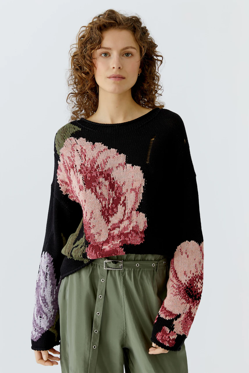 Damen-Pullover mit buntem Blumenmuster, lässig kombiniert mit einer lockeren Hose.