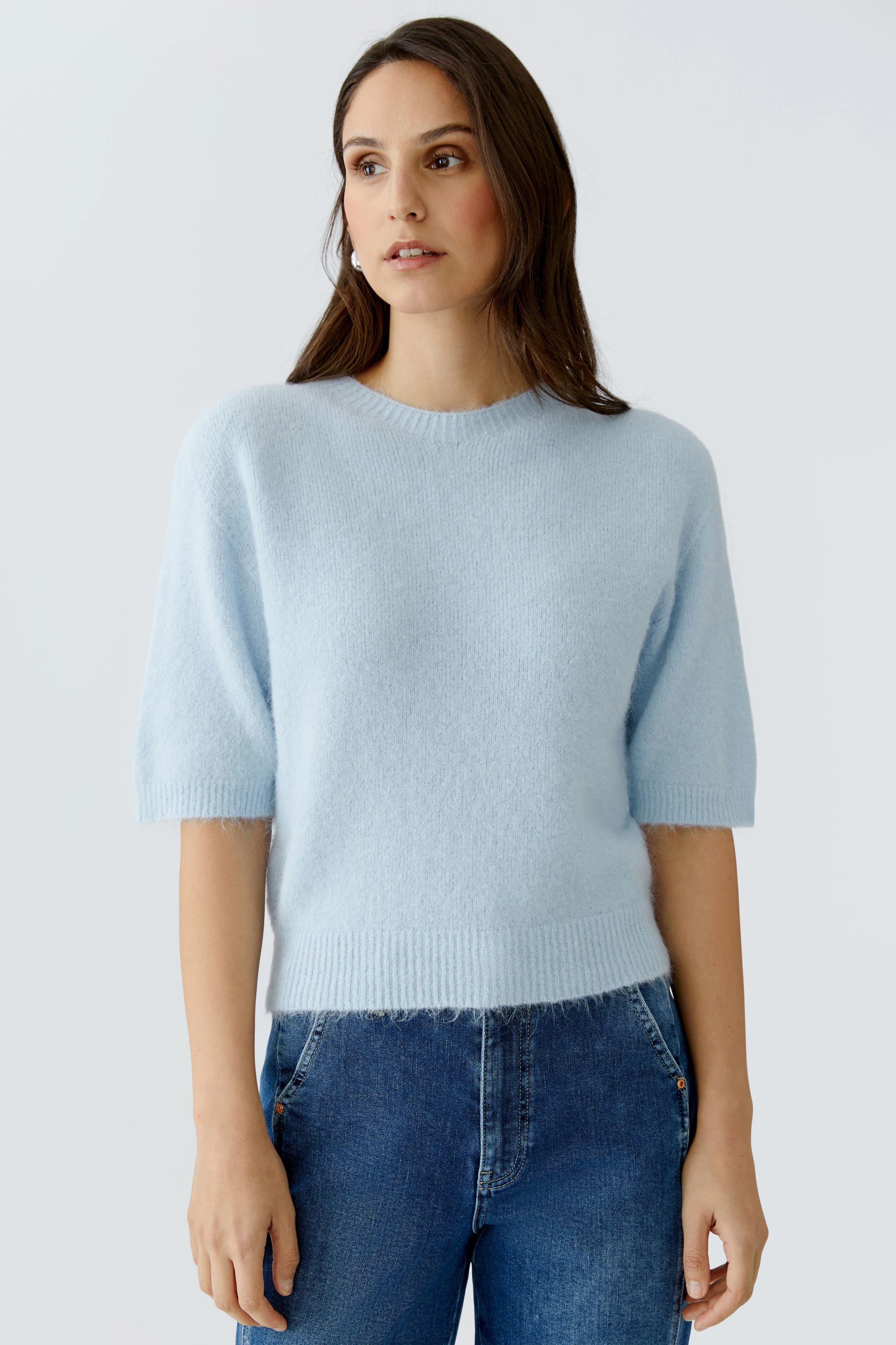Leichter Damen-Pullover in Hellblau mit kurzen Ärmeln, kombiniert mit lässigen Jeans.